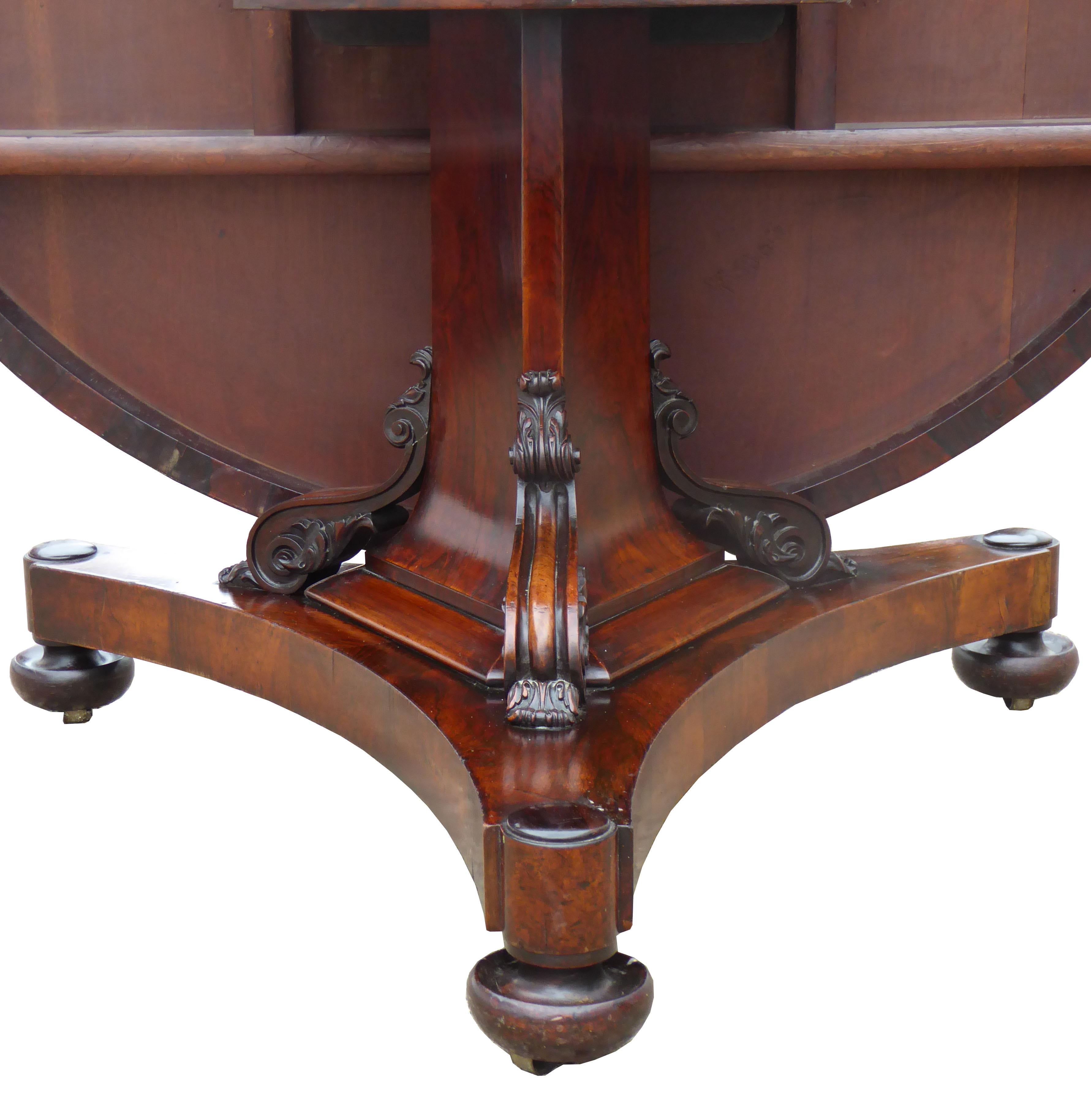 For sale is a good quality Regency Rosewood circular breakfast table. The has a nicely figured rosewood top, above a triangular column, terminating on the platform base, with ornately carved corbels. The table is in an excellent, original condition,