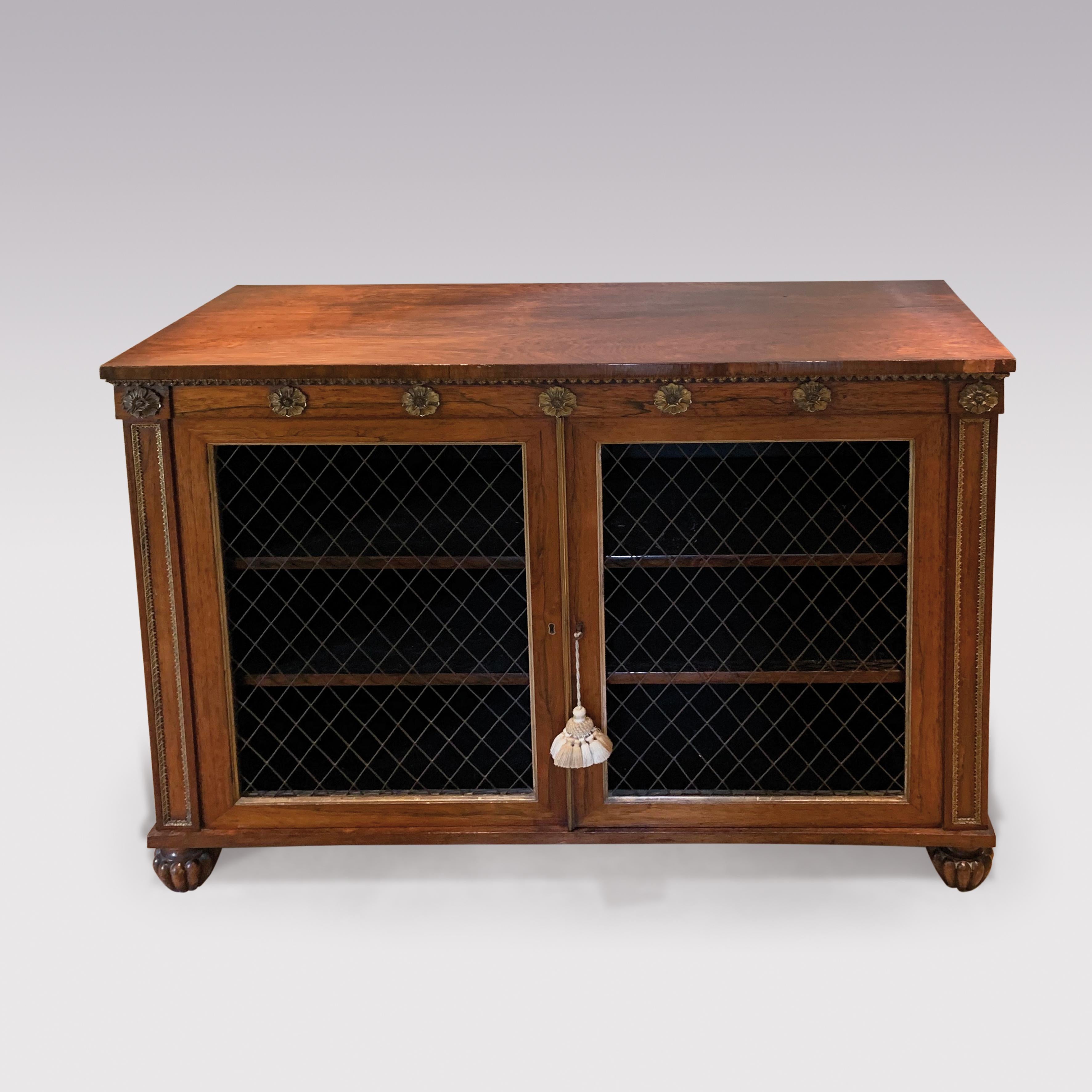 An early 19th century Regency period rosewood Chiffonier, having gilt-brass paterae mounted frieze above wire grill doors flanked by panel columns ending on carved melon feet.