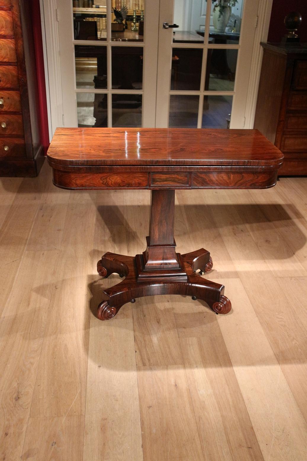 Beautiful stylish rosewood wall table. Sheet can be turned and folded out making it a gaming table. The play sheet is provided with a round felt insert. Felt is slightly weathered. Superb base and everything in rosewood. Beautiful drawing of the