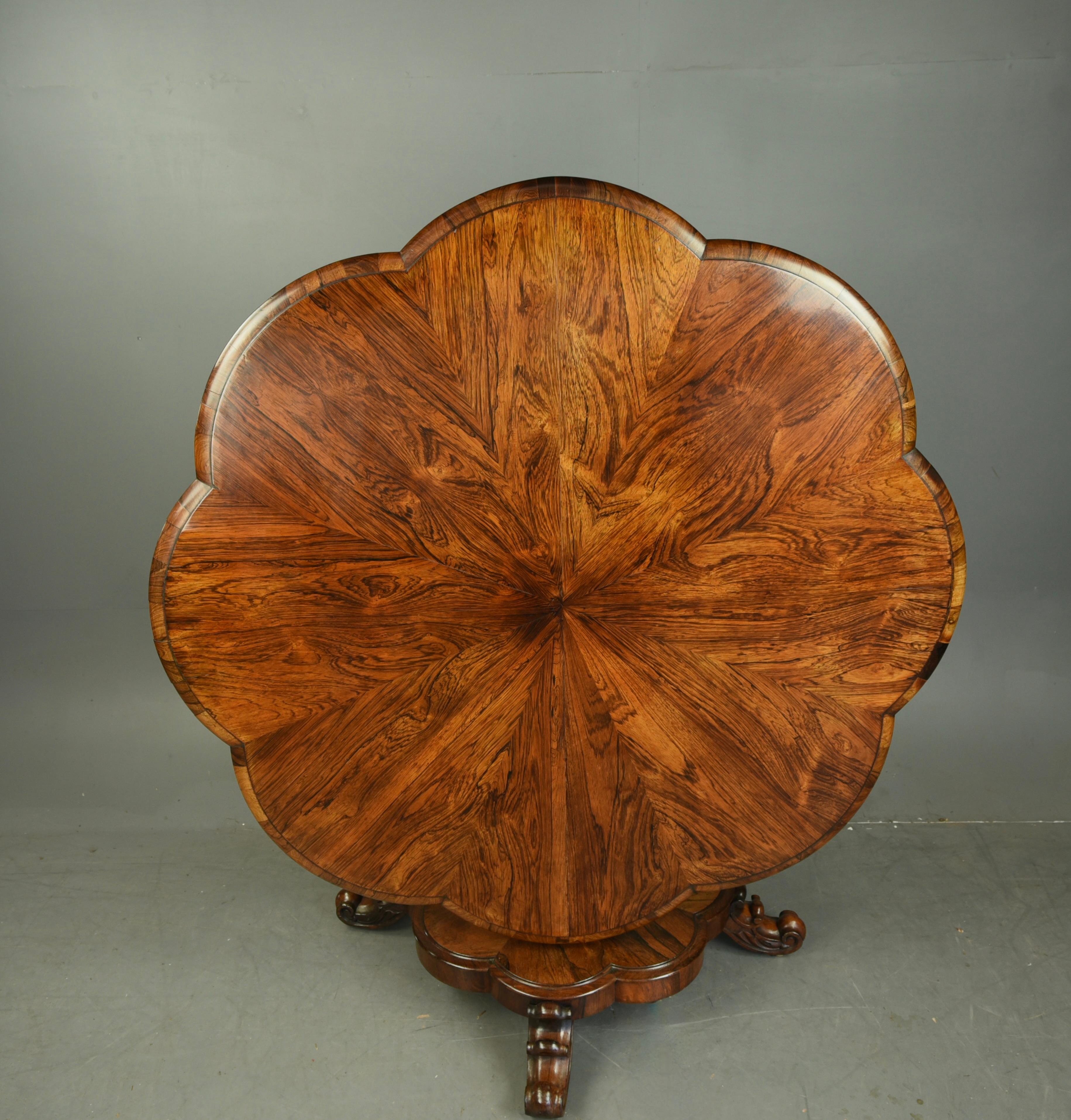 Fantastic Quality circular unique shaped Rosewood breakfast table ,
The top has a wonderful unusual shape with a fantastic grain and colour ,with a tilt top action standing on a conforming base with four scroll carved feet with hidden castors .
It