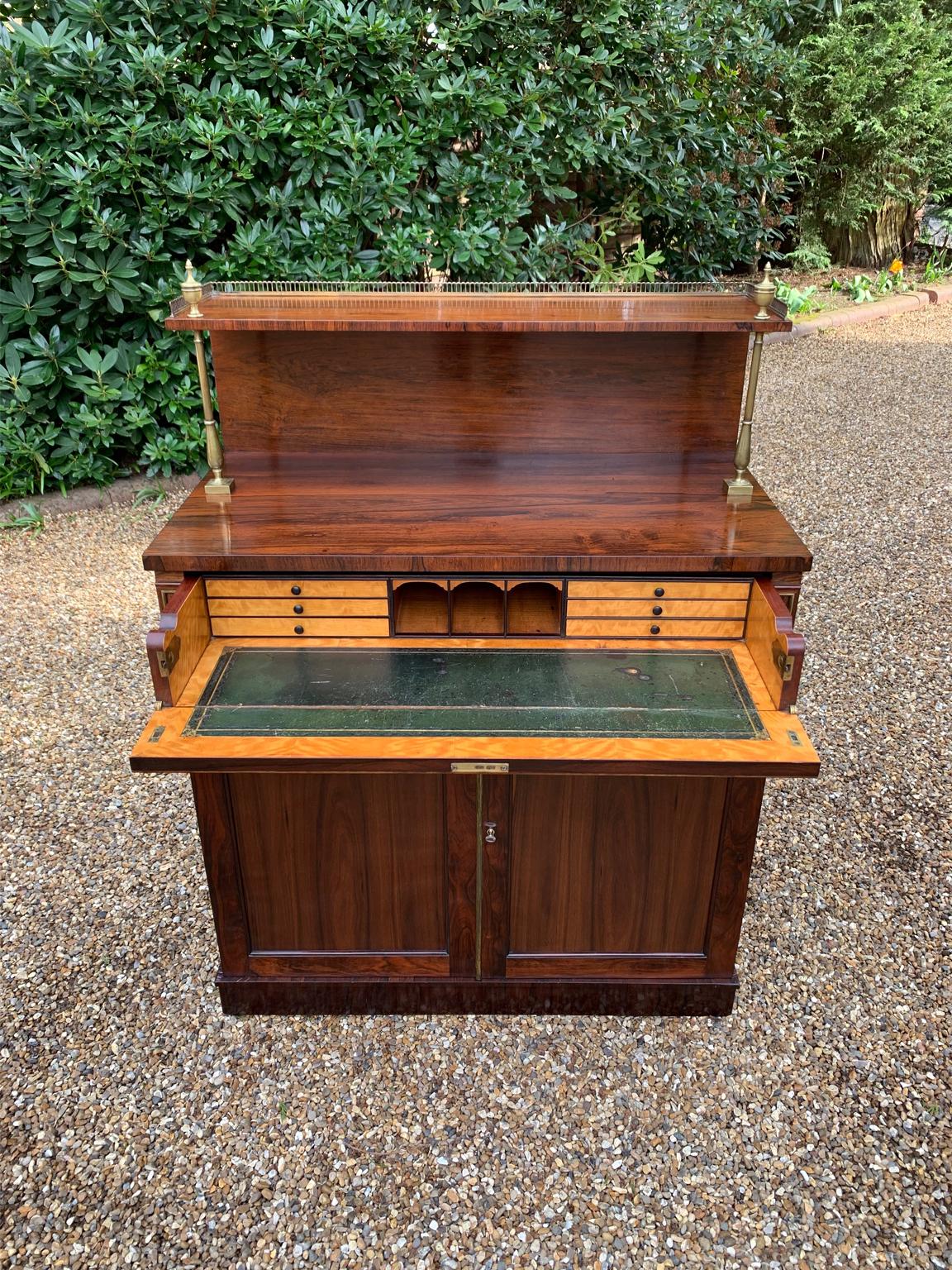19th Century Regency Rosewood Secrétaire Chiffonier, supported by baluster brass columns, brass galleried ledge over the single secretaire drawer with lion brass ringed handles, fitted satinwood interior, leathered writing surface, three pigeon