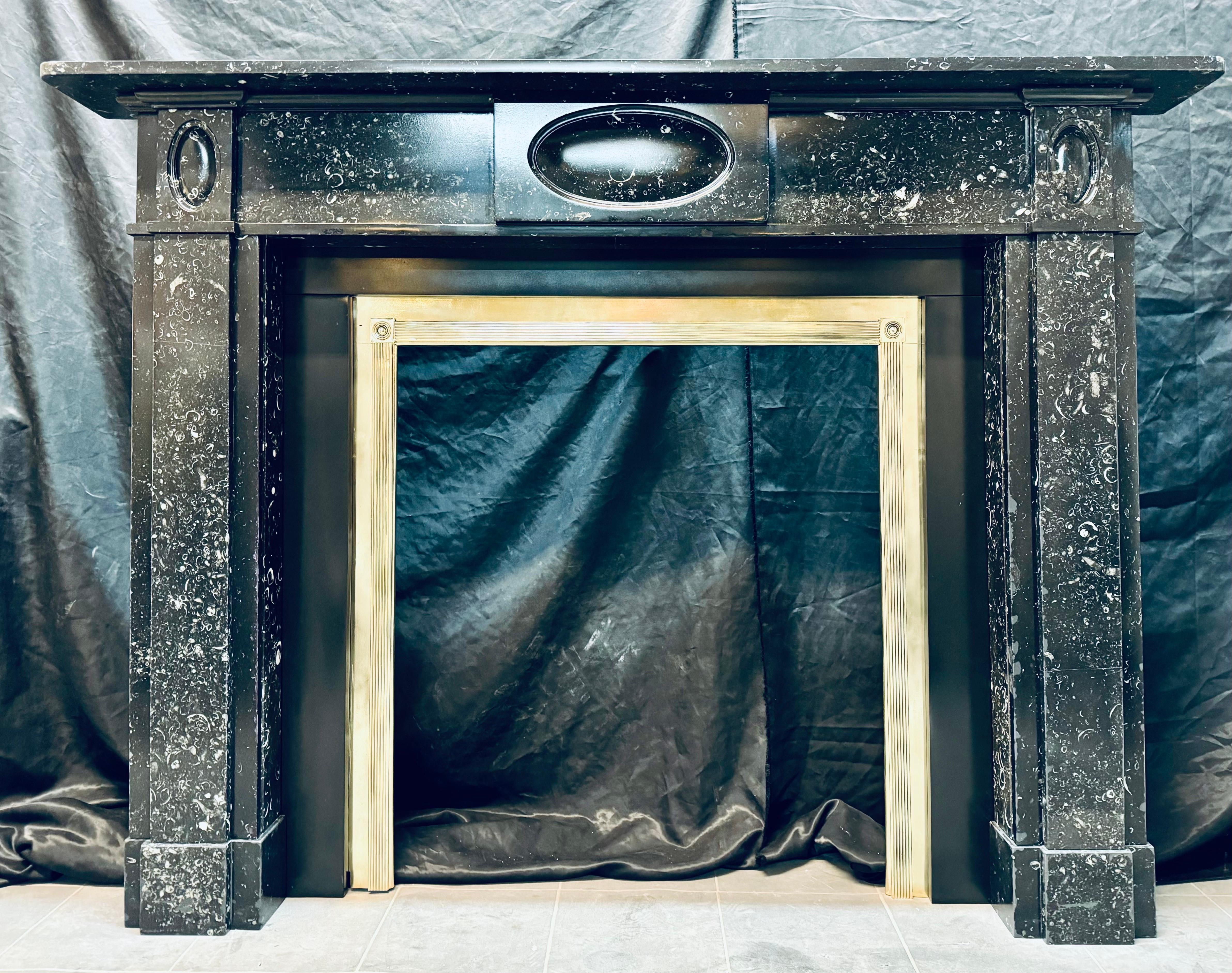 Eine seltene Regency Edinburgh New Townes 19. Jahrhundert Kilkenny fossilen Marmor Kamin Surround. Ein schlichtes Regal befindet sich über einem Fries mit einer zentralen, vertieften ovalen Tafel, über einem geschnitzten Gesims, das die Pfosten