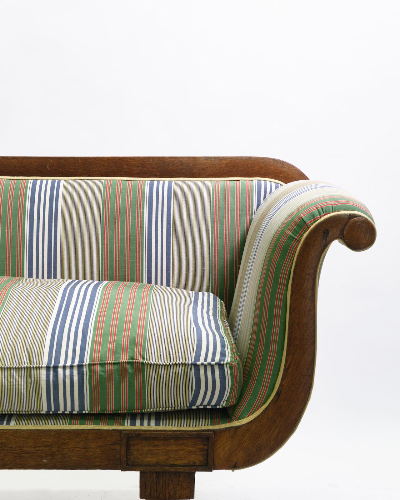 A 19th century Regency sofa upholstered in Adam Bray striped fabric.

The sofa is made with an oak frame, and down-filled upholstery raised on brass castors.