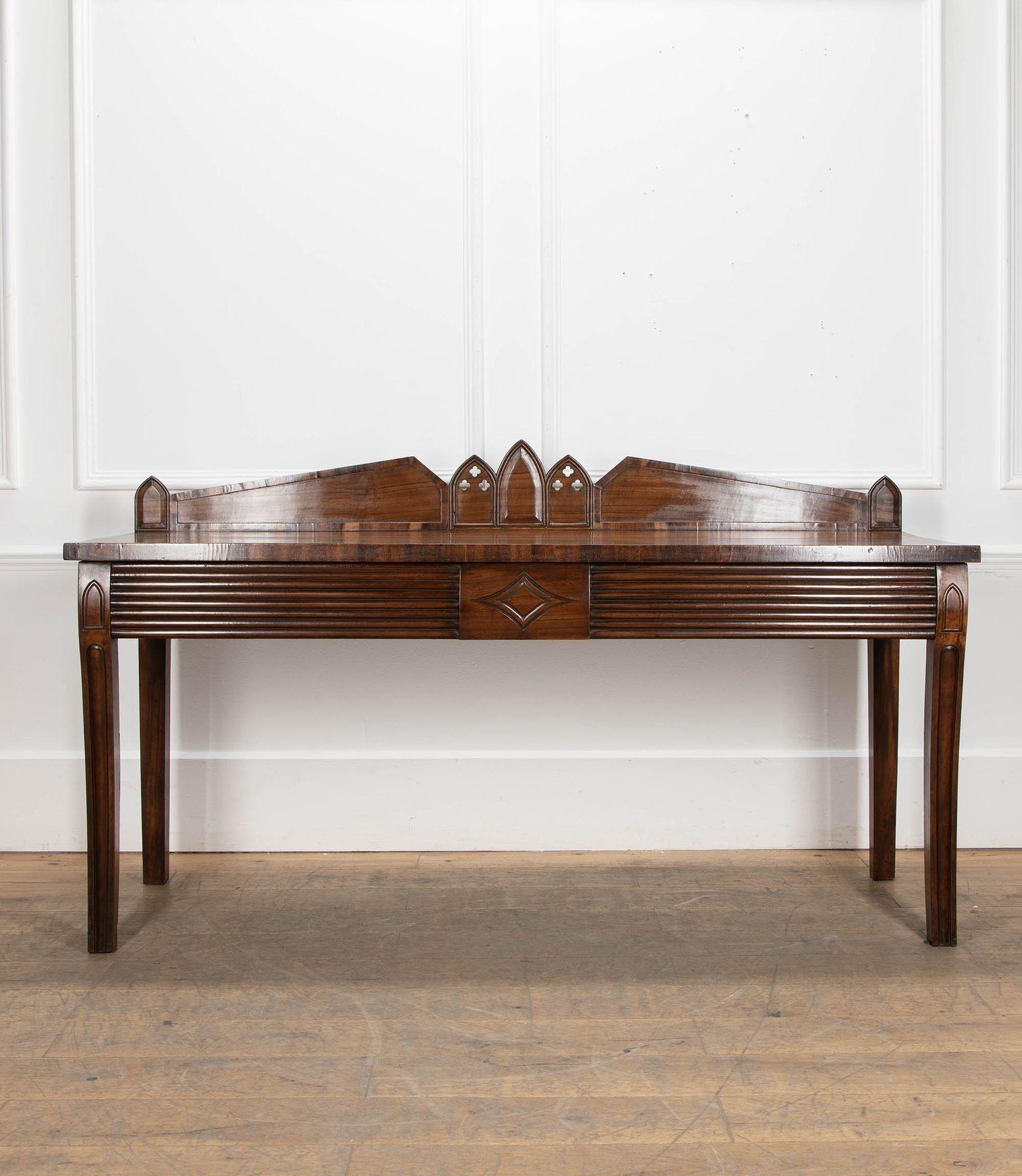 Un bel exemple de table de service Goncalo Alves de style Regency anglais, datant de la fin du 19e ou du début du 20e siècle.
Le dos arqué est centré par trois flèches gothiques, le sommet rectangulaire est surmonté d'une frise cannelée et de