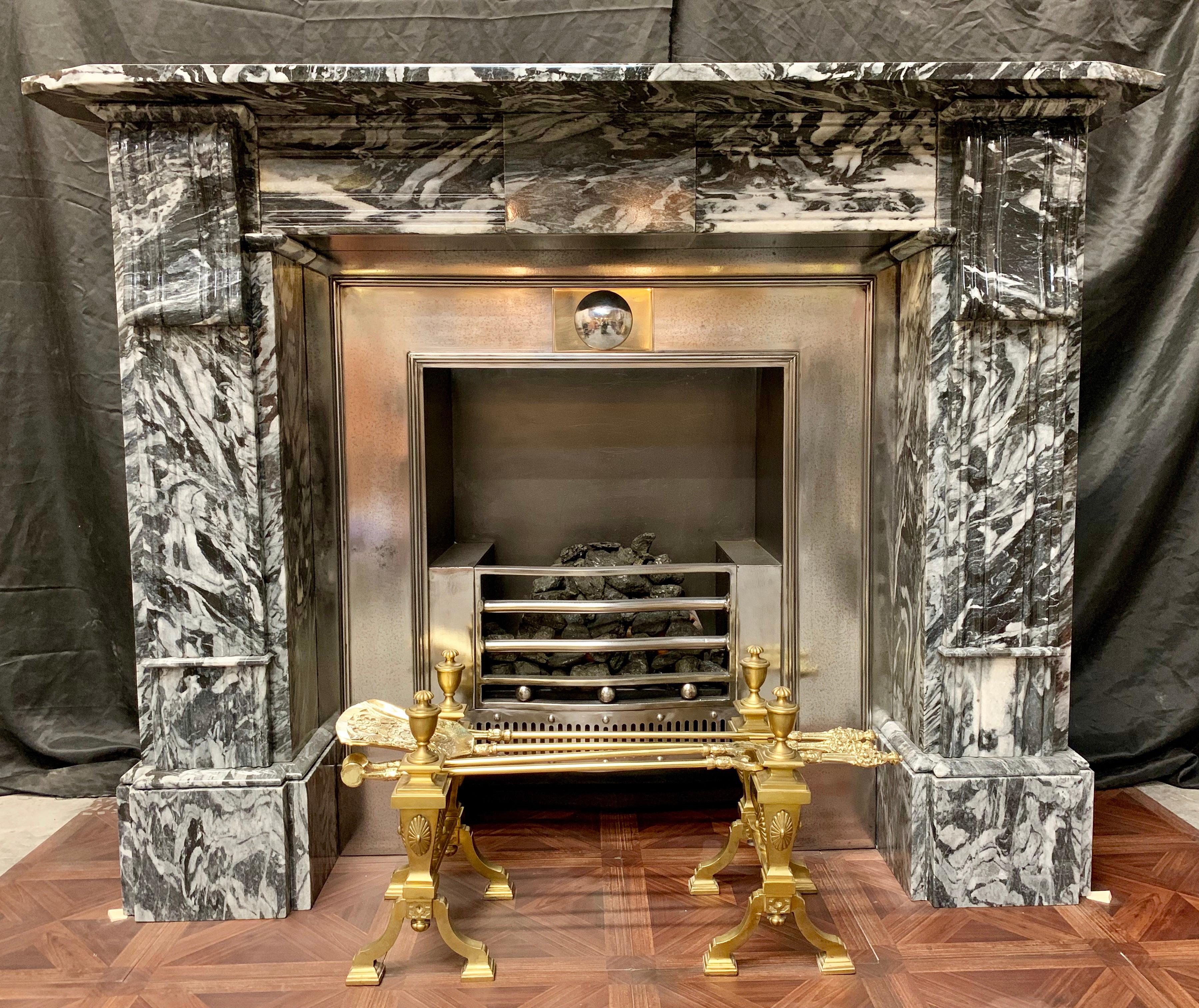 An unusual and charming 19th century Regency style Lumacella di San Vitale marble fireplace surround, a deep square splayed shelf sits above a frieze of carved reeding with a central unadorned tablet, flanked and supported by jambs displaying large