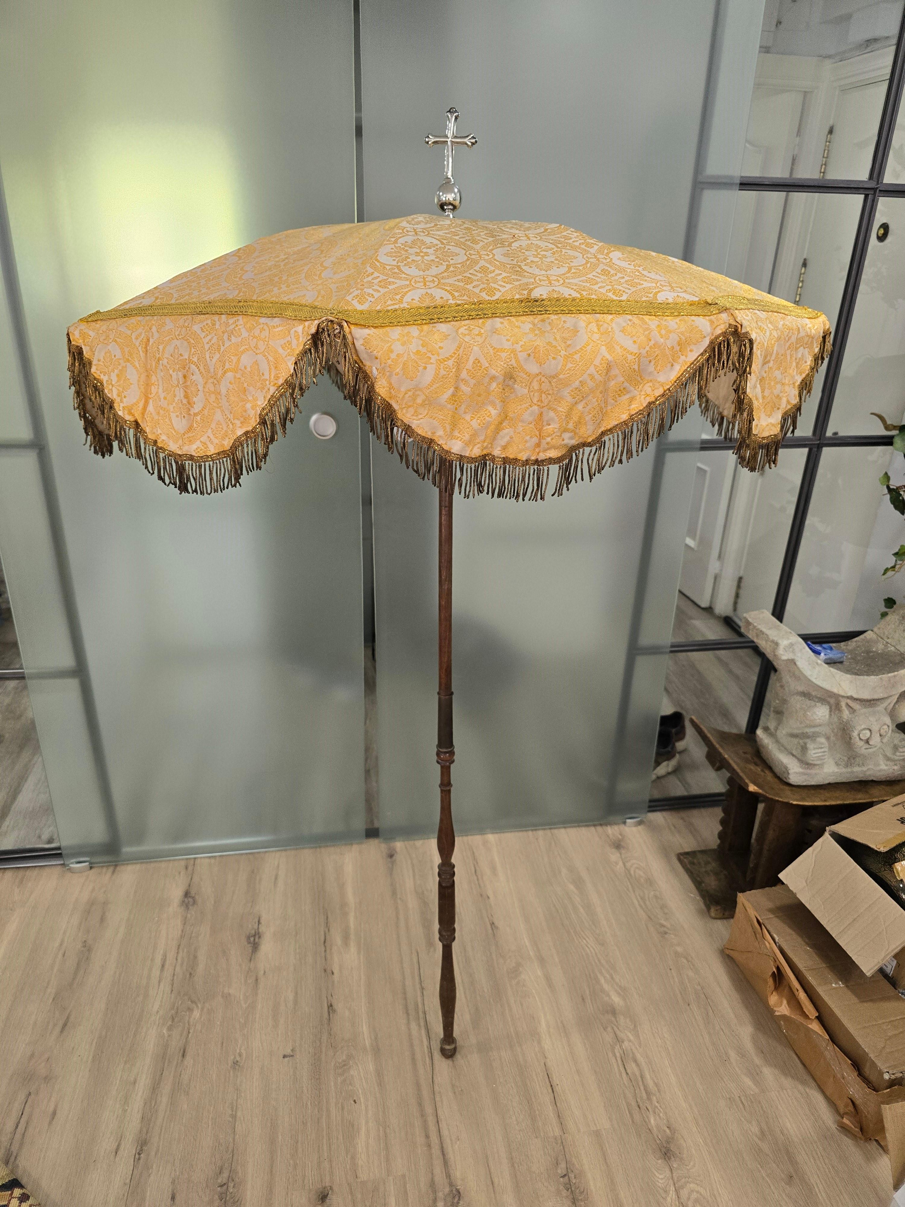 Cet intrigant parasol religieux du XIXe siècle présente une croix en argent et un tissu cousu avec du fil d'or. Il est en excellent état et conserve son étui d'origine. Lorsqu'il est déployé, il mesure 100 cm de diamètre et 120 cm de hauteur, tandis