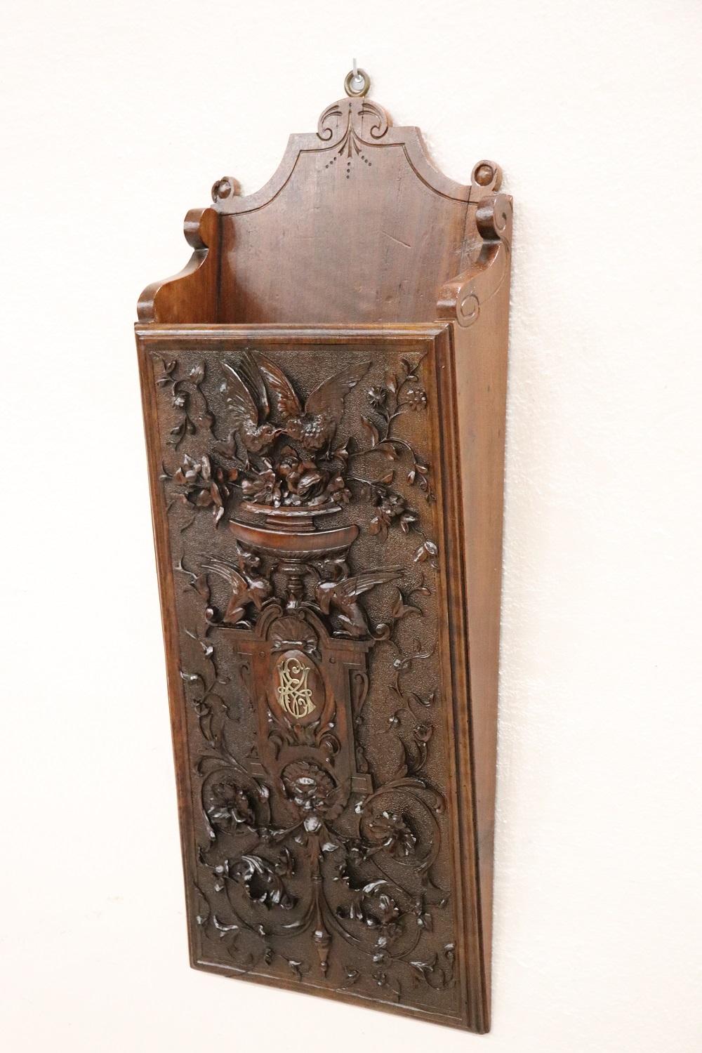 Beautiful Italian renaissance style wall magazine rack, 1880. Made of solid walnut wood. Characterized by a refined and elaborate decoration carved in the wood. Many decorative elements of Renaissance taste such as two winged dragons and a grotesque