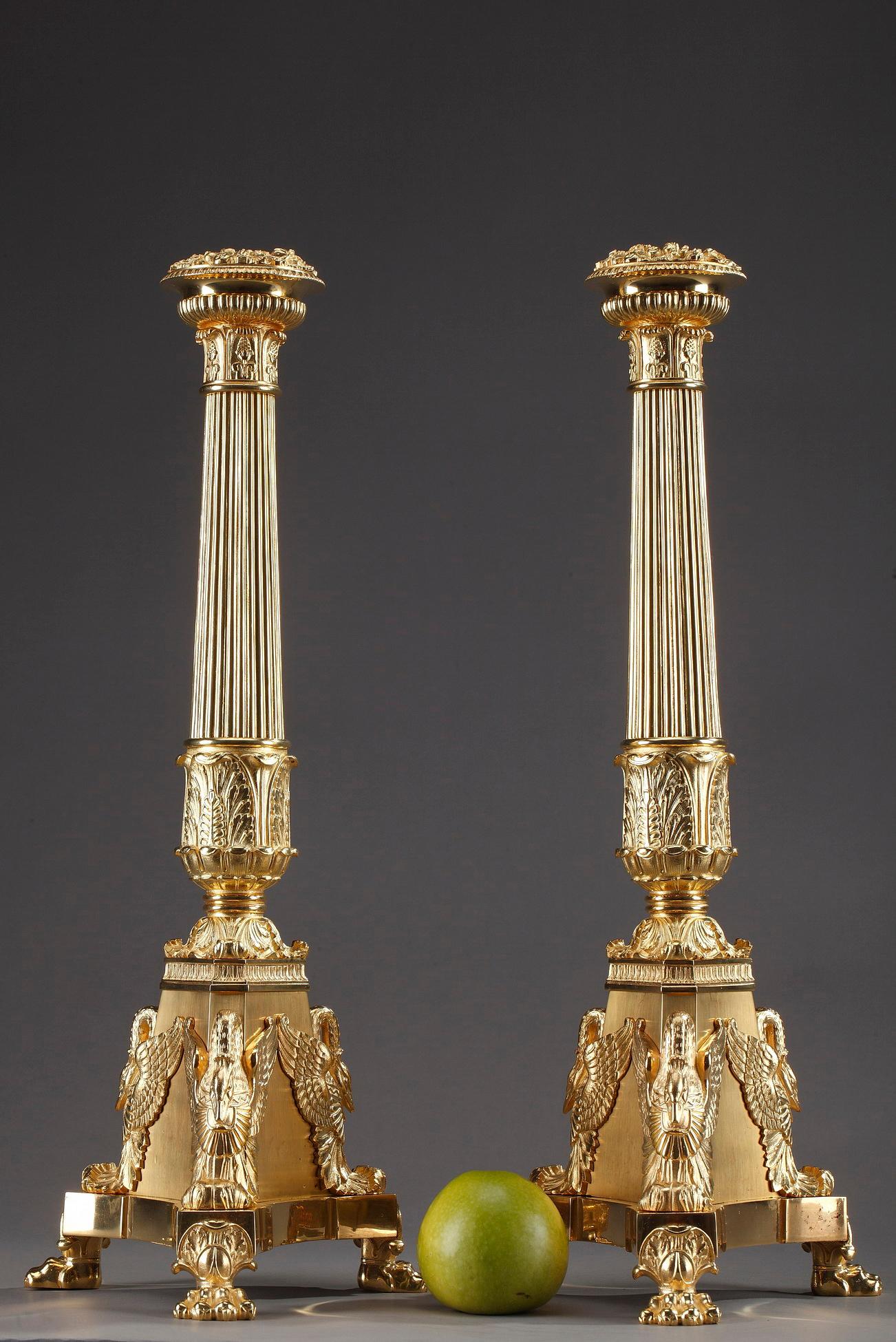 Large candelabra in gilt and chiselled bronze from the Restauration period. The fluted stems of the candlesticks are embellished with pines, palmette and acanthus leaves. The nozzle is topped with a rich ring of flowers and fruits. Each candelabra