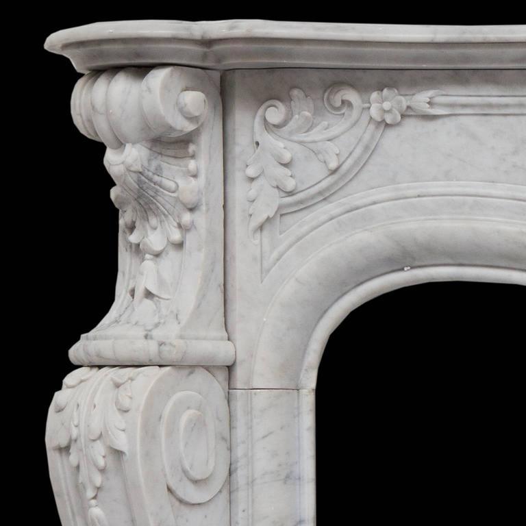 A rich and beautiful 19th century antique French sculpted Louis XVI white Carrara marble fireplace mantel.
Hand carved with a serpentine shelf with, detailed frieze which is powerfully carved together with a foliated shell, flowers and panels. The