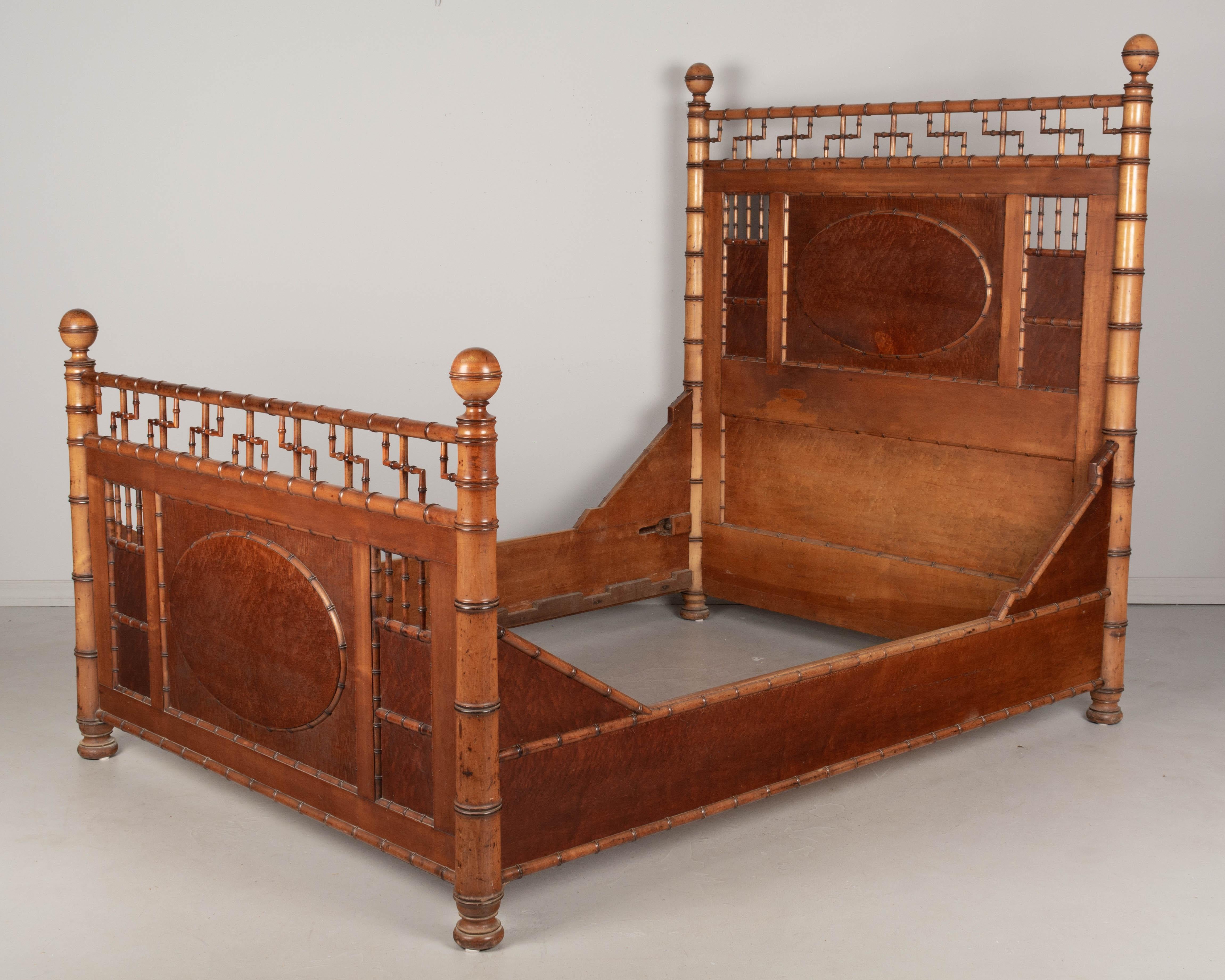 A 19th century American Victorian Aesthetic Movement faux bamboo bed frame by R. J. Horner & Co. made of solid cherry and birdseye maple. All original with amber stained finish and nice aged patina. This bed has a large oval paneled headboard and