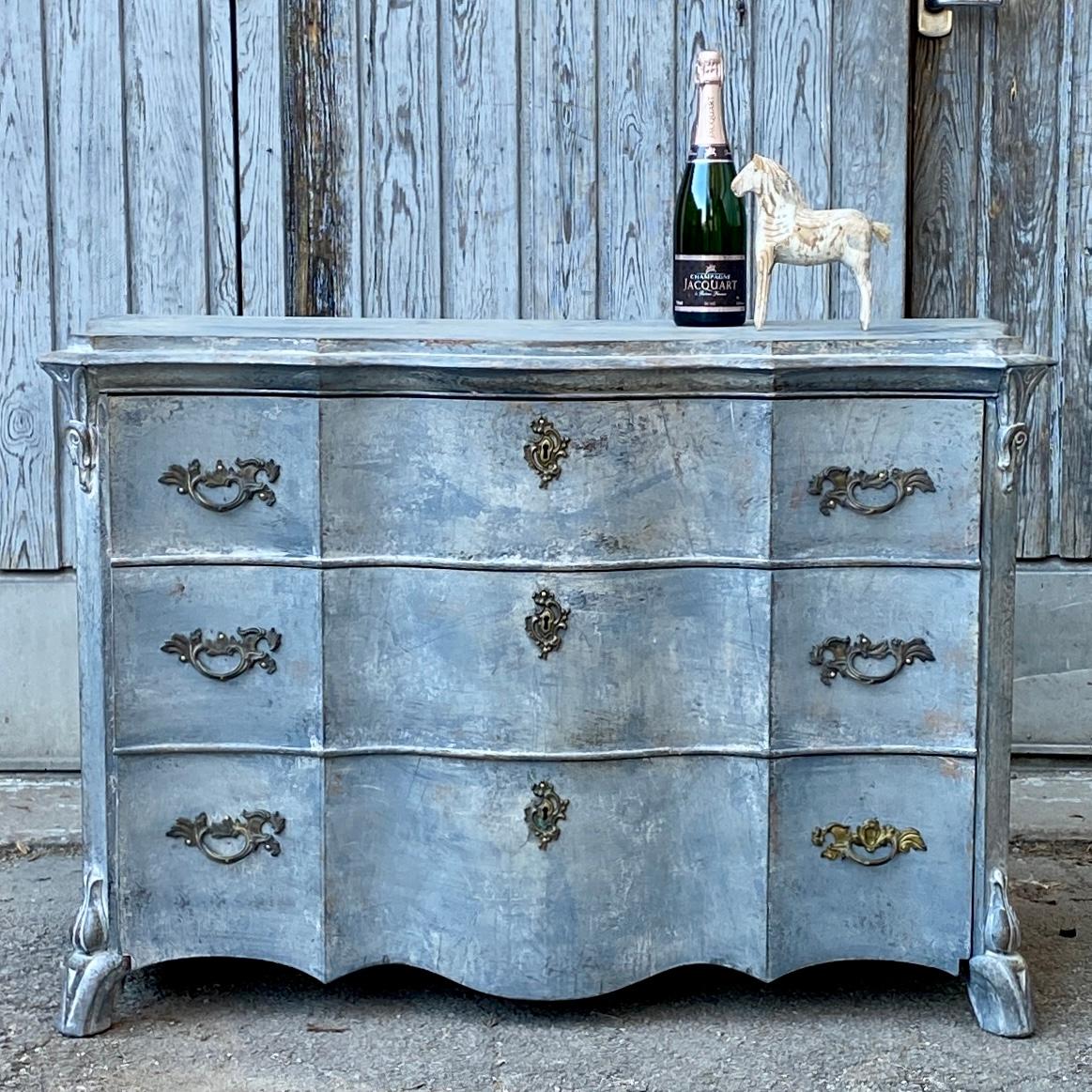 Swedish dresser in Gustavian blue paint with three drawers and original 19th century Bronze Hardware. 
This Rococo style chest or drawers is from the mid 1800-hundres. The simplicity of the Scandinavian Folk Art 