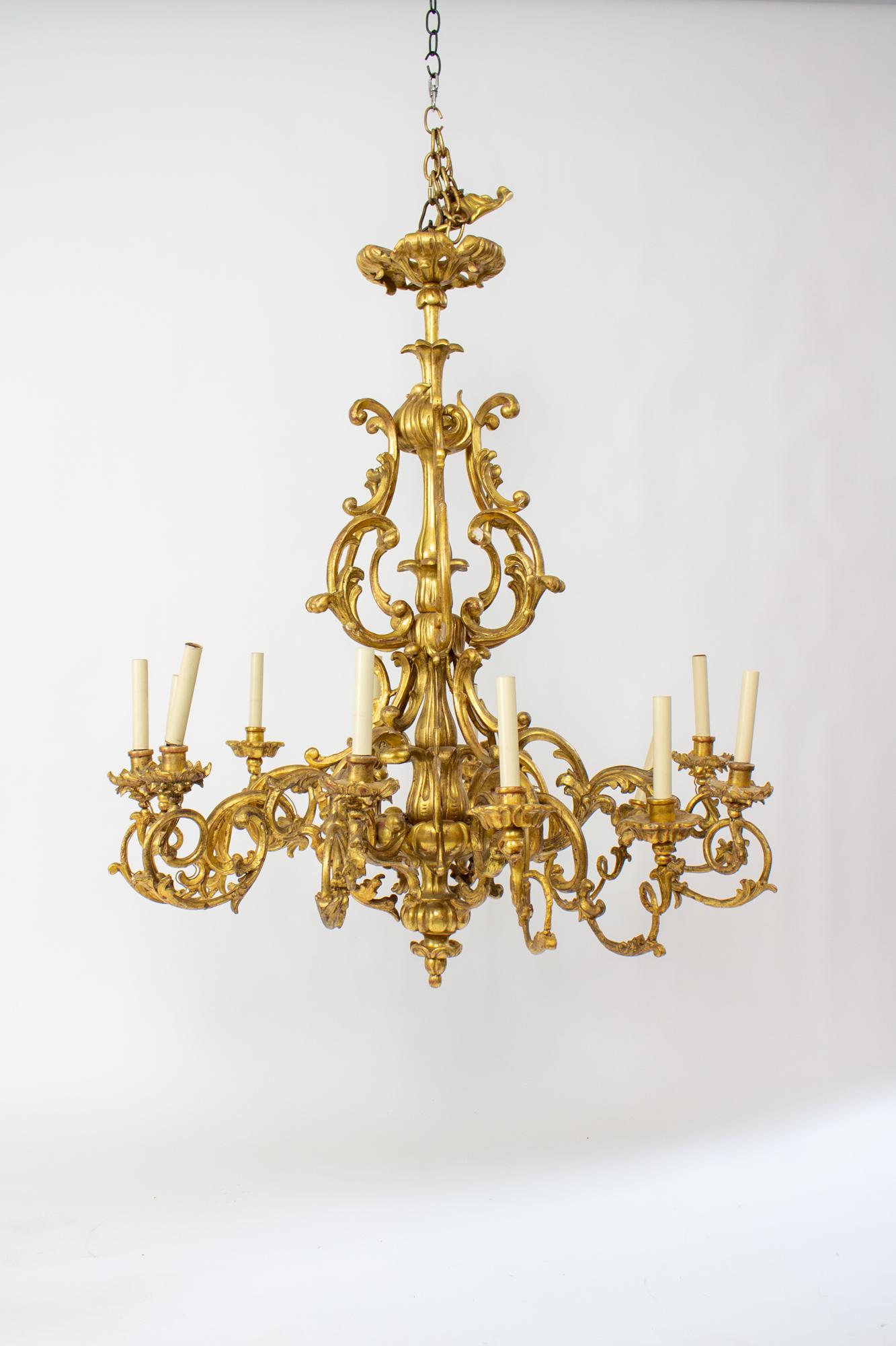 19th century Rococo French giltwood pair of chandeliers. These are large chandeliers, 42” in diameter and 47” in Height, and are suitable for a truly palatial space. Ornate and organic in form, with arms swooping in a twisting fashion around the