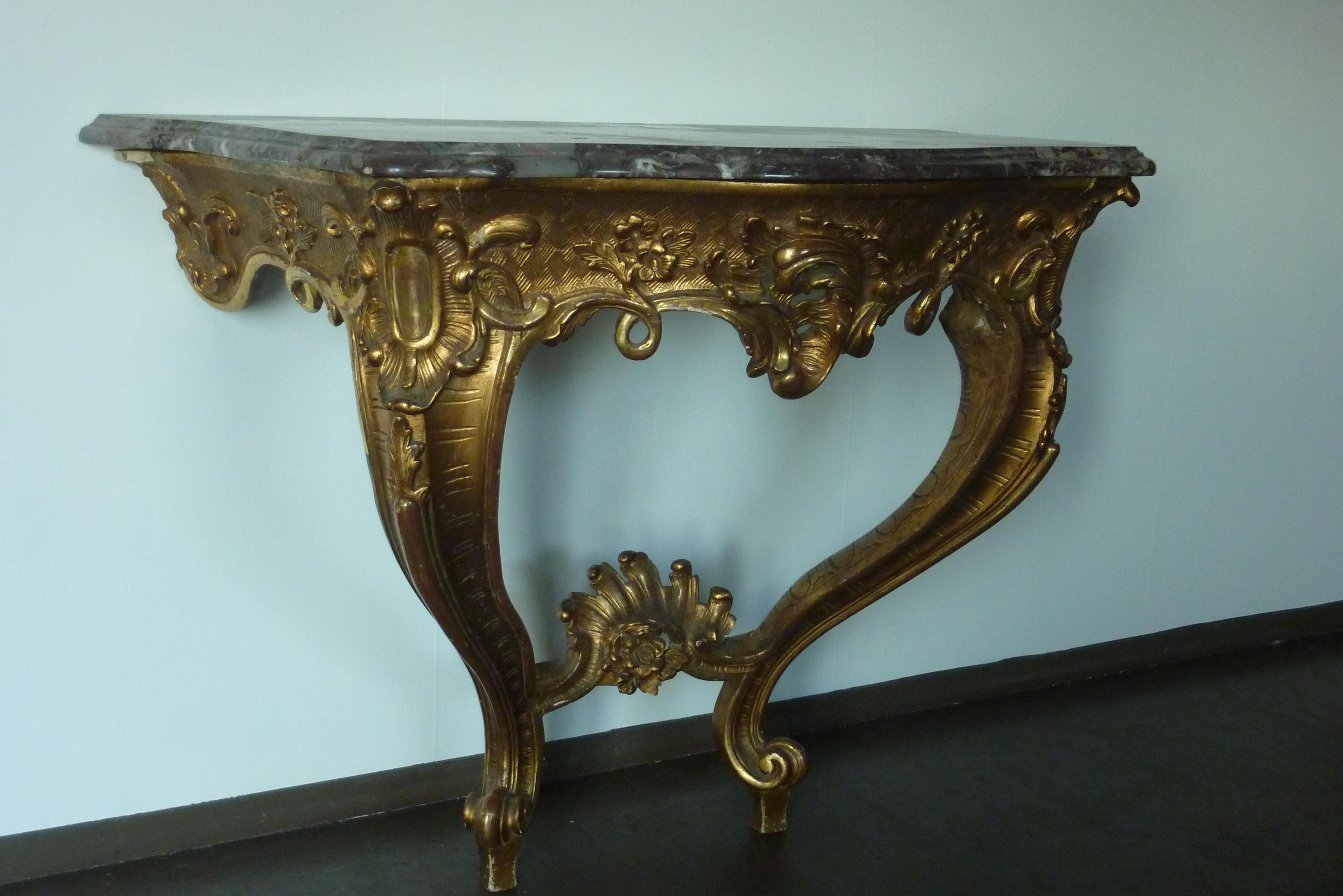 19th Century Rococo Louis XV Style Gilded Console Table with a original Marble Top.
The hardwood base is plated with gold leaf, the ornaments are made from a combination of chalk and bone glue.
The console table is made between 1850 and 1870.
The