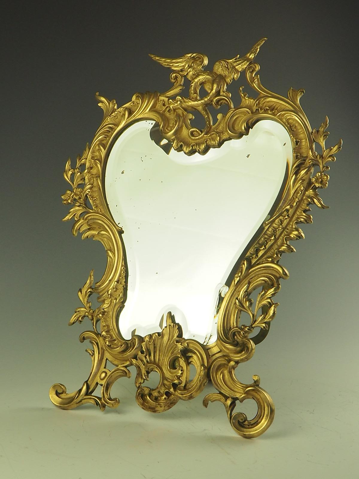 19th Century Rococo Revival Cartouche Shaped Mirror is a true testament to the exquisite craftsmanship of the era. The mirror boasts an original quality bevelled mirror plate, ensuring a clear and crisp reflection. The ornate wrythen frame is a work