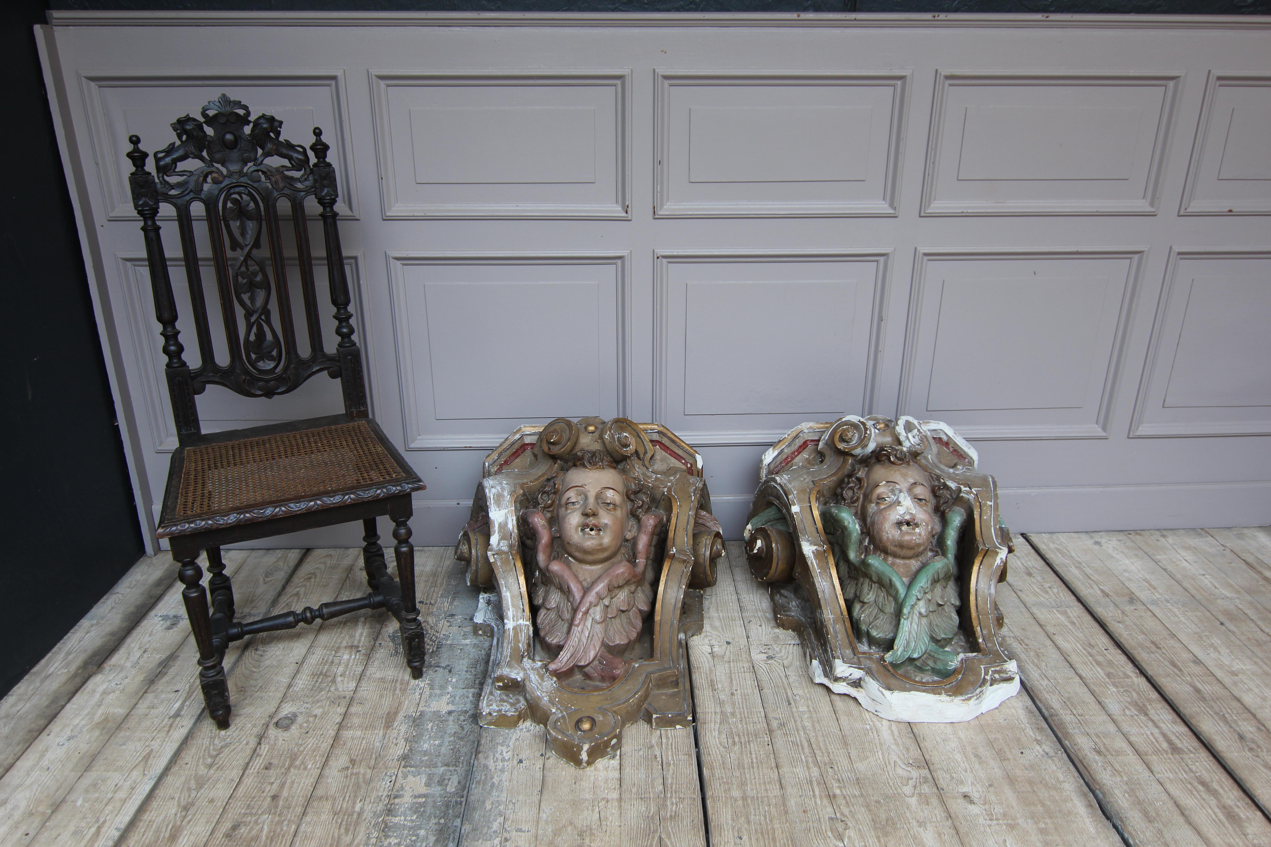 A 19th-century unique pair of Rococo style consoles with putti heads. Carved from plaster and painted in polychrome. 
The consoles are open from the rear and the top. Most likely they were part of a water feature and served as a water fountain (see