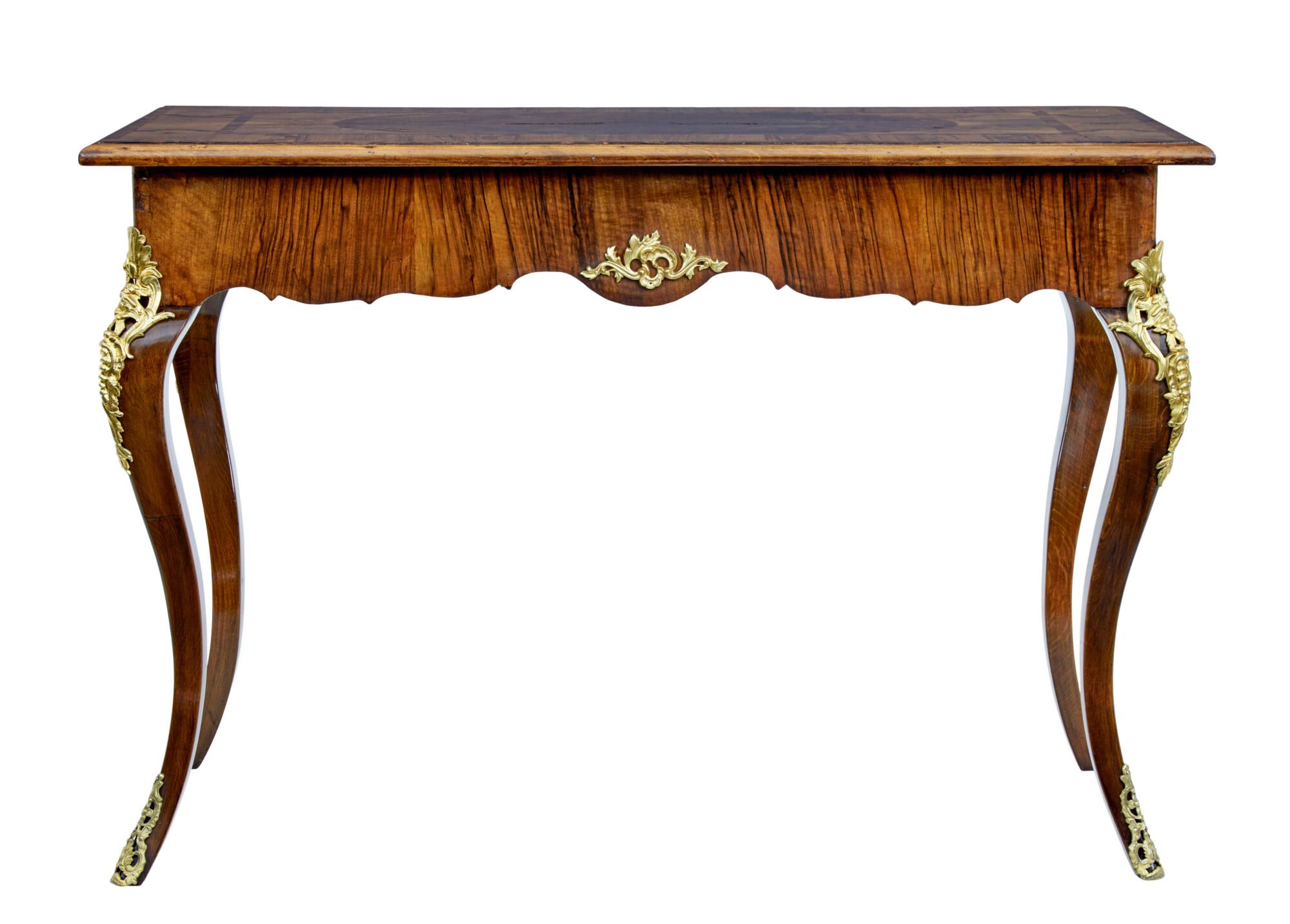 Beautiful walnut inlaid side table circa 1830.

Top surface with contrasting walnut veneers arranged into a symmetrical design.  Shaped frieze with decorative ormolu mounts on each side.  Further mounts on the top of cabriole leg and to the base of