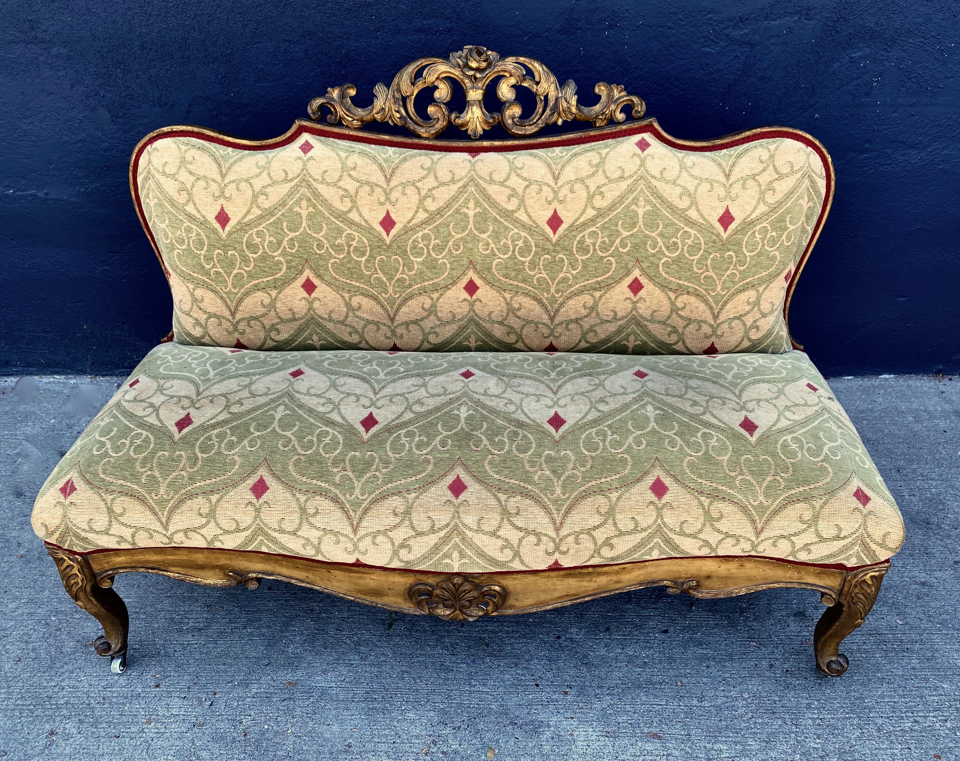 This is a charming mid-19th century carved Italian or Spanish gilt wood settee or bench. The bench features shell carved cabriole legs ending in snail-form feet. The scrolling seat frame is centered by a carved gilt wood medallion. The serpentine