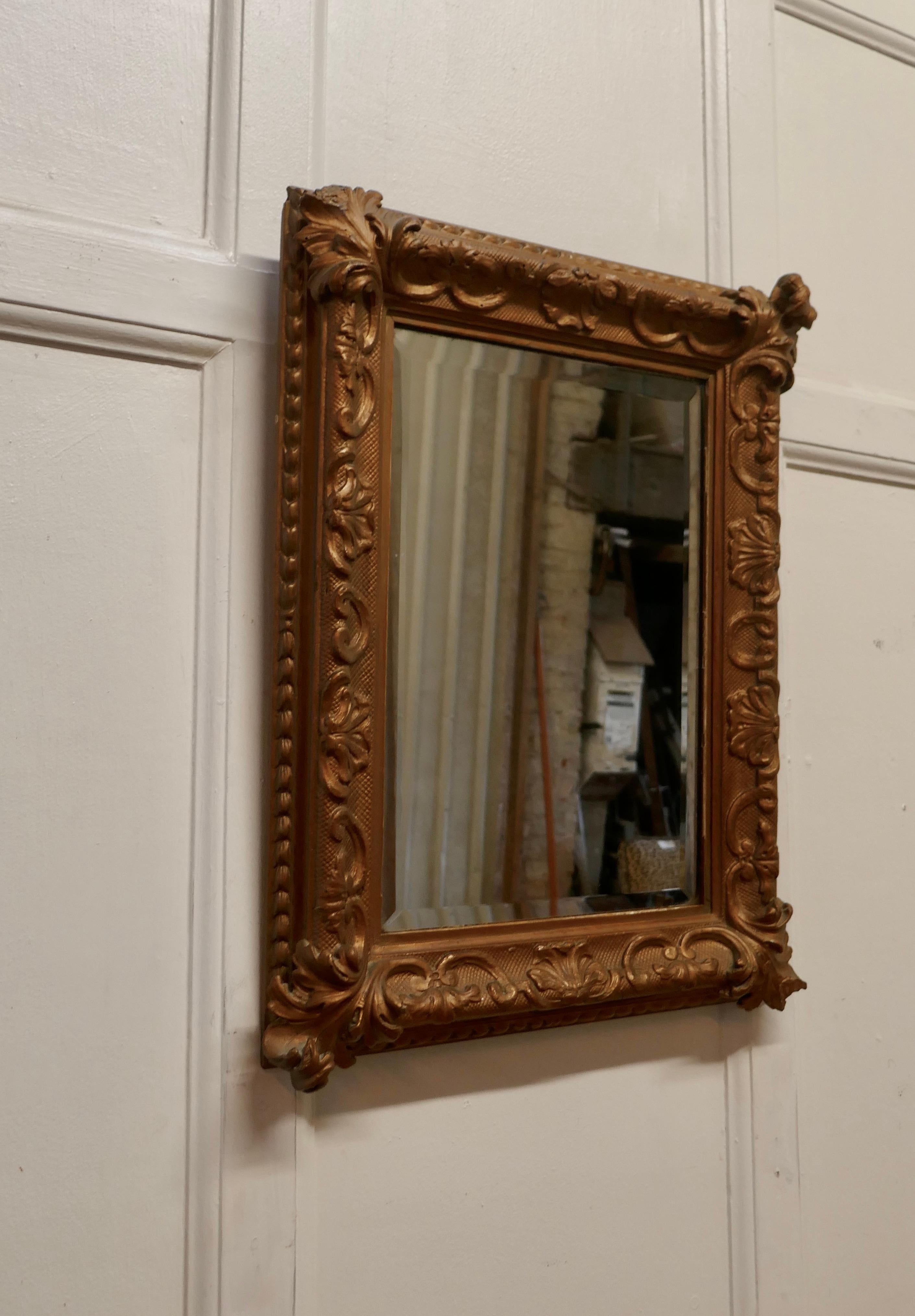 19th century Rococo style giltwood wall mirror

The 3” wide deeply carved Gilt frame has a rococo leaf and swag decoration all the way around the rectangular frame
The mirror frame is in fair condition it has some losses and it has a bevelled