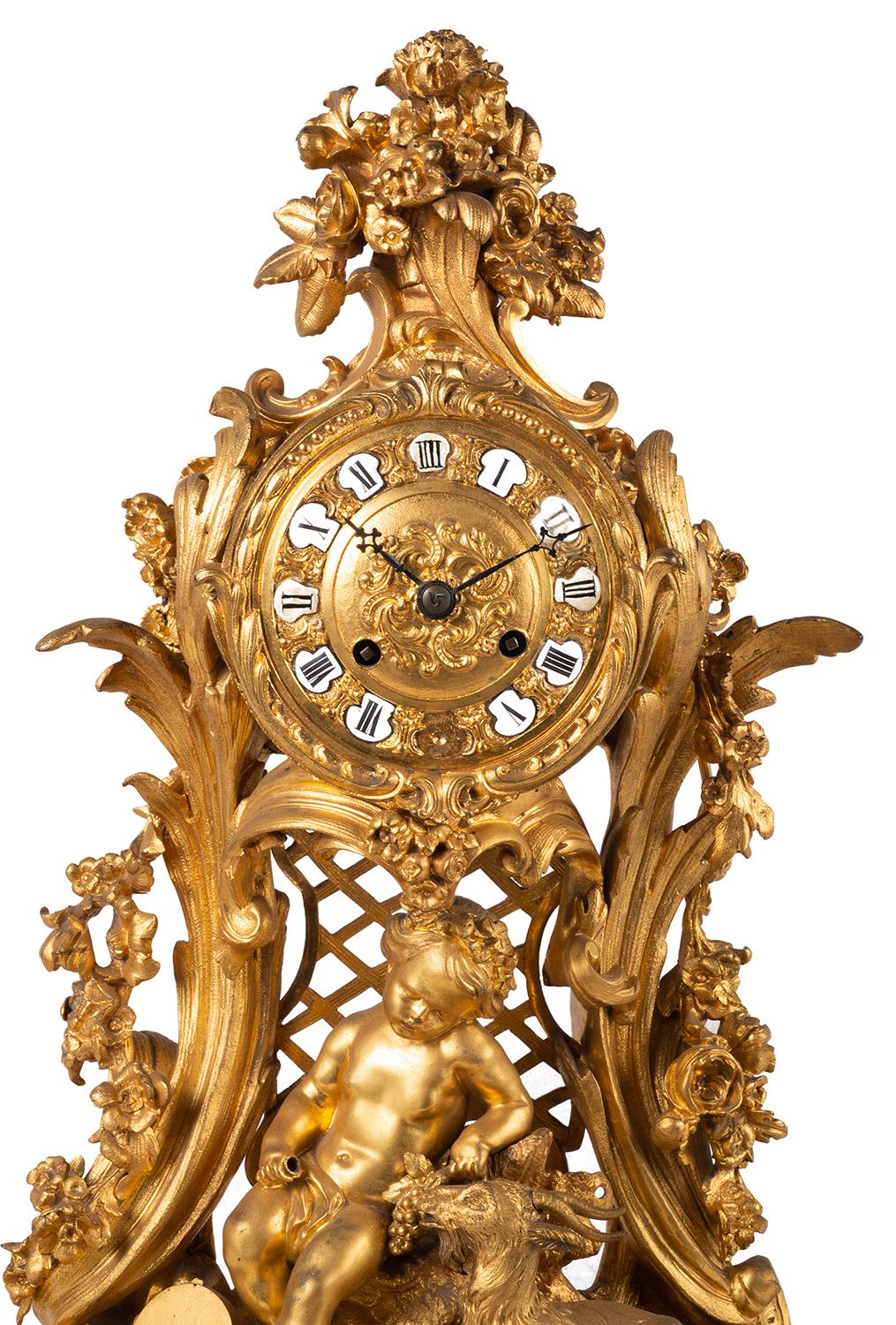 A very good quality 19th Century French gilded ormolu Rococo influenced mantel clock, having wonderful scrolling foliate decoration, the clock face having enamel Roman numerals, an eight day duration movement that strikes on the hour and half hour,