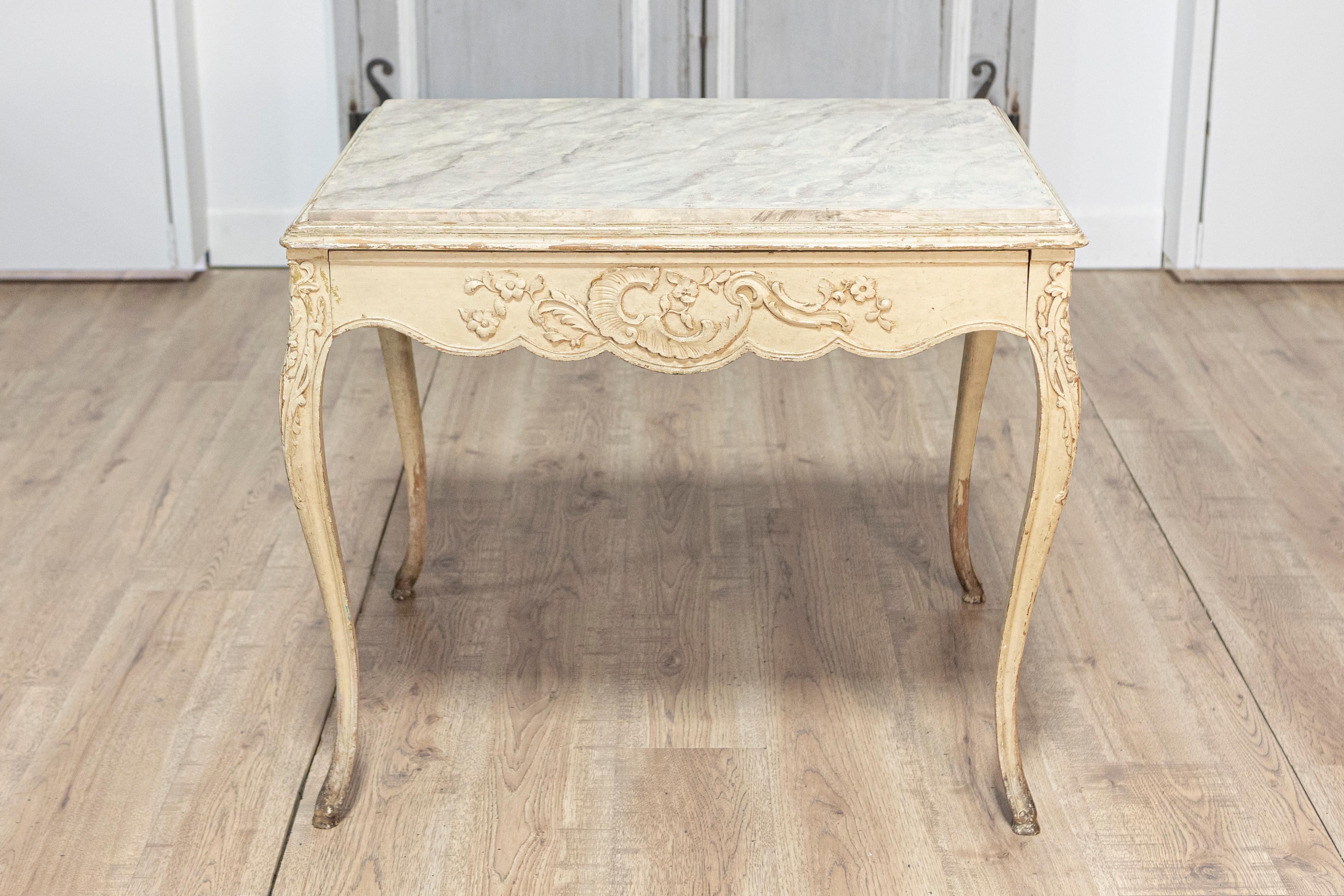 Dieser exquisite Tisch im Rokokostil aus dem 19. Jahrhundert, um 1890, zeigt die Eleganz und Opulenz der Rokokoästhetik. Er ist aus massivem Buchenholz gefertigt und zeichnet sich durch kunstvoll geschnitzte Blumen- und Blattmotive aus, die die