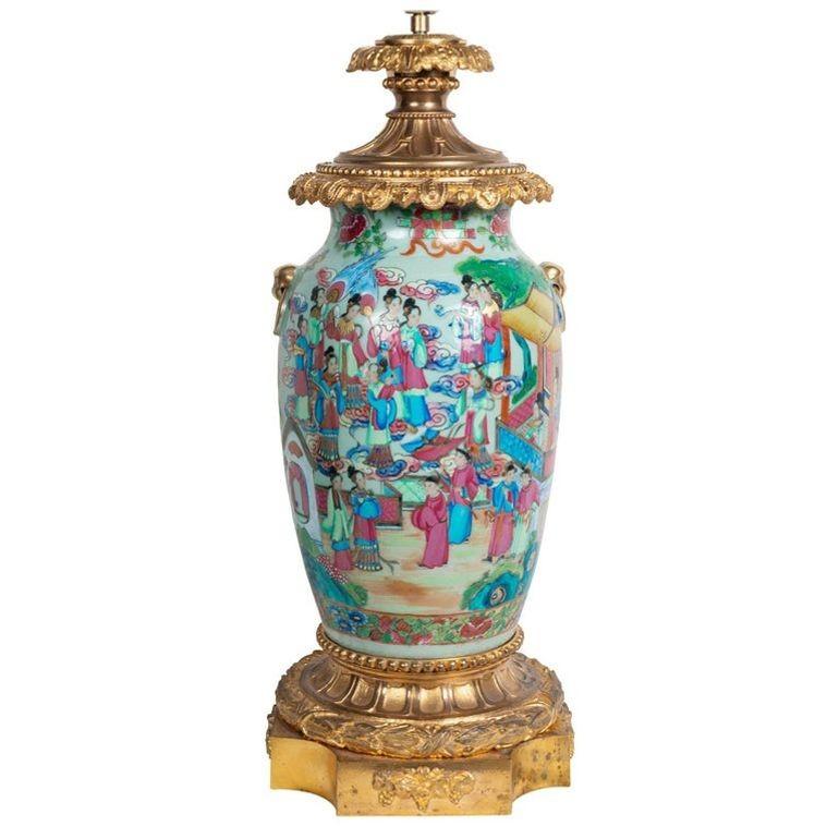 Vase / lampe cantonais de très bonne qualité du 19e siècle, avec médaillon rose, et de magnifiques montures en bronze doré au sommet et à la base. Scènes orientales classiques peintes à la main, représentant de nombreux courtisans, motifs et