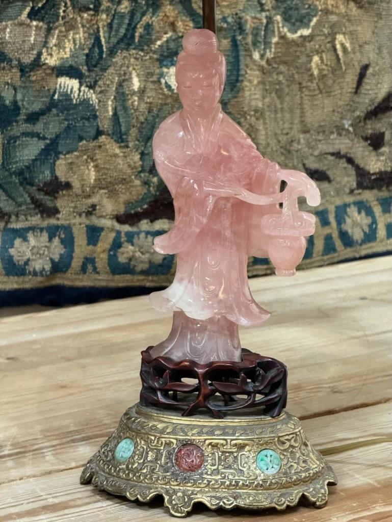 Rose quartz Goddess with flower basket figure, 19th Century Chinese.  Mounted on a hardwood stand with a further metal stand inlaid with 2 jadeite and 1 agate roundel.  Mounted as a lamp.  Height of figure is 8.75”, Total heigh of lamp 25”.  Base