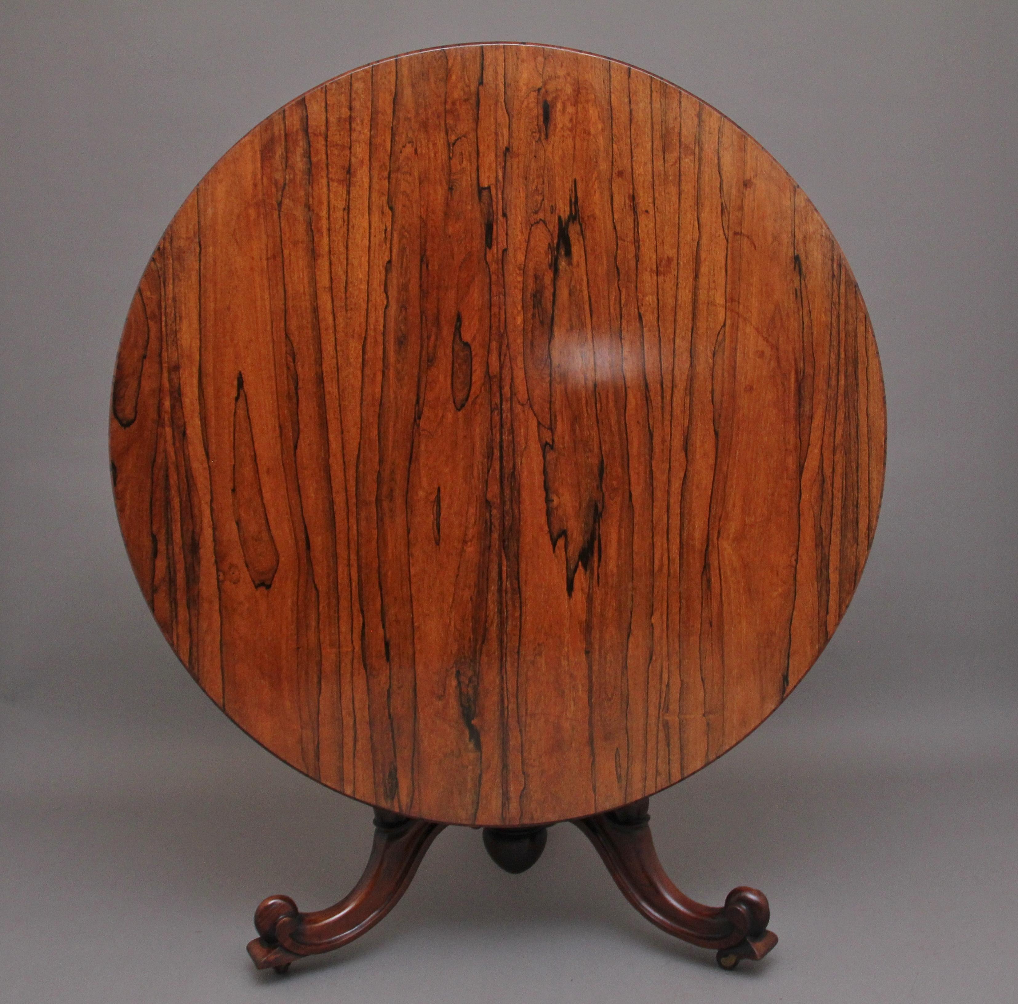 19th century rosewood tilt top breakfast / centre table, with a beautifully figured top with frieze below, supported on a turned tulip shaped column with three carved cabriole legs terminating on carved scroll feet. In excellent condition and having