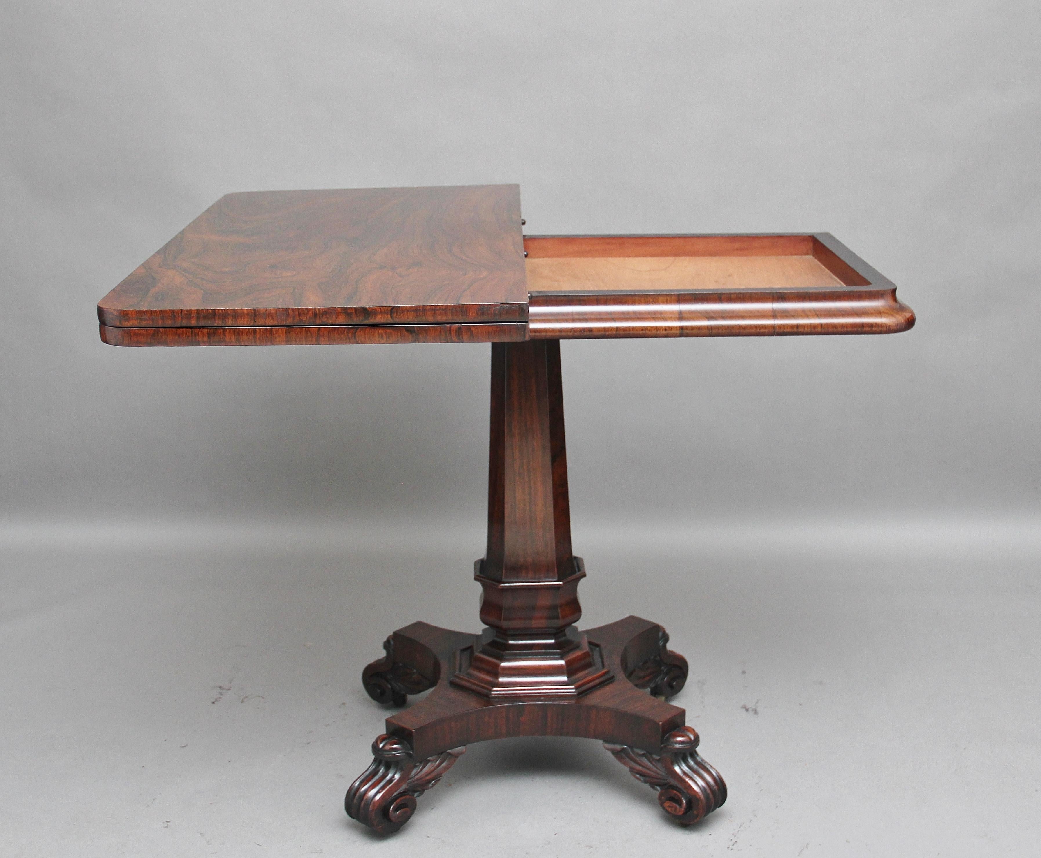 19th century rosewood card table, the moulded rectangular top turning and opening to reveal a green baize playing surface, supported on an elegant shaped column standing on a shaped platform base with four carved scroll feet. Lovely color and in