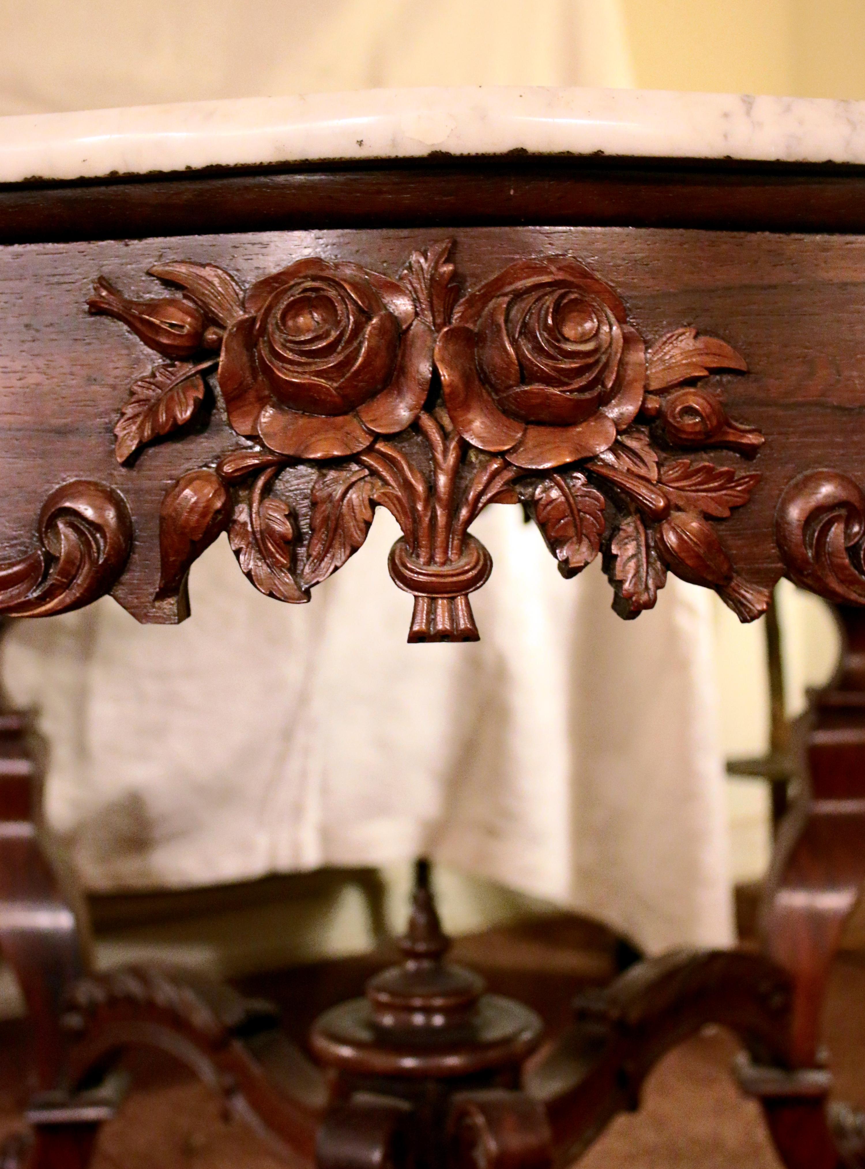 Rococo Revival center table attributed to the prestigious New York firm of Joseph Meeks. Heavily hand carved rosewood featuring floral bouquets and rosettes, graceful serpentine legs, fanciful stretchers and beveled white marble top. See