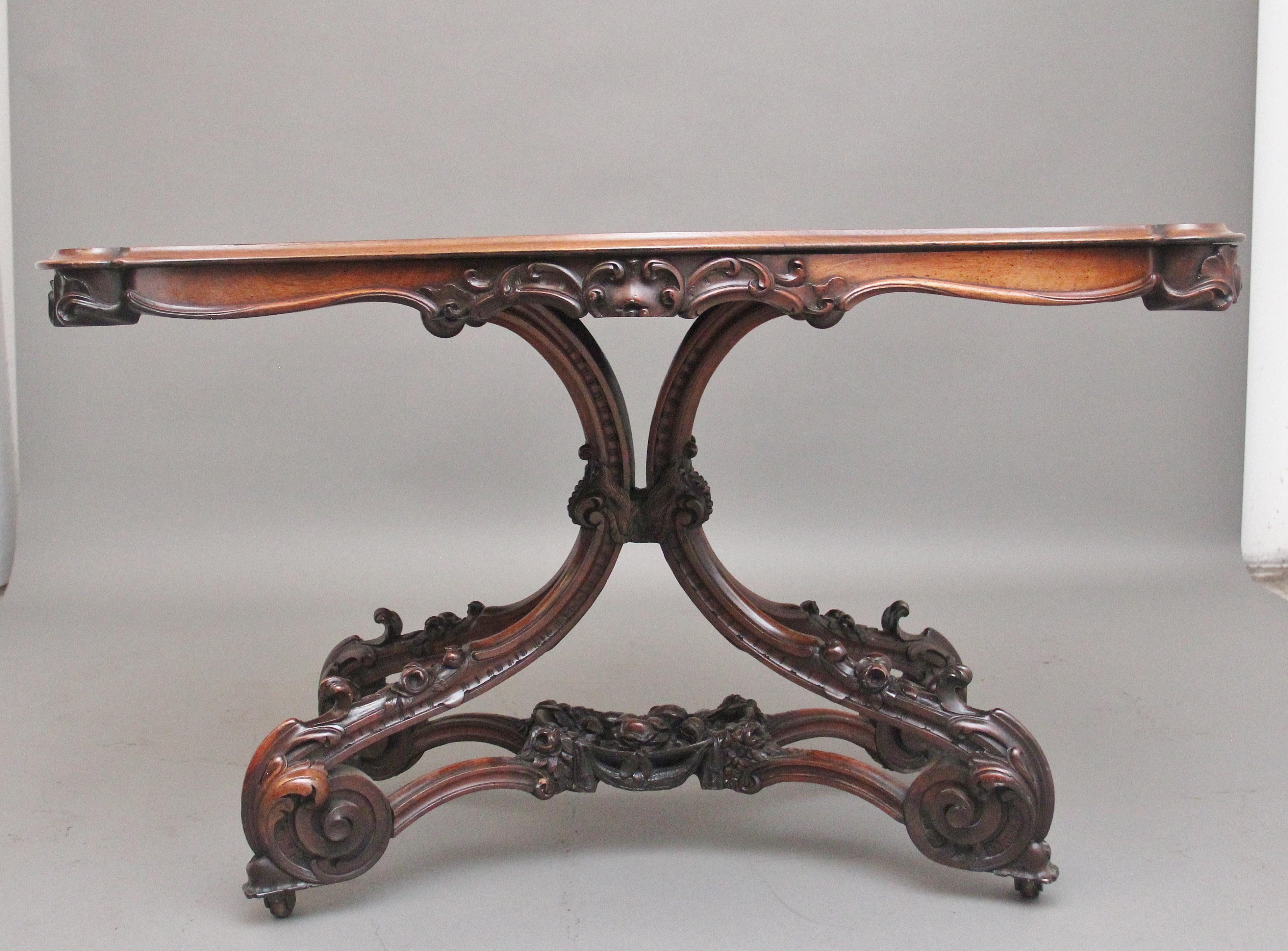 Mesa de centro de palisandro del siglo XIX, de magnífica calidad, con el tablero maravillosamente labrado, perfilado y moldurado sobre un friso tallado que incorpora decoración floral y de conchas, apoyado sobre una base cuádruple ornamentada y
