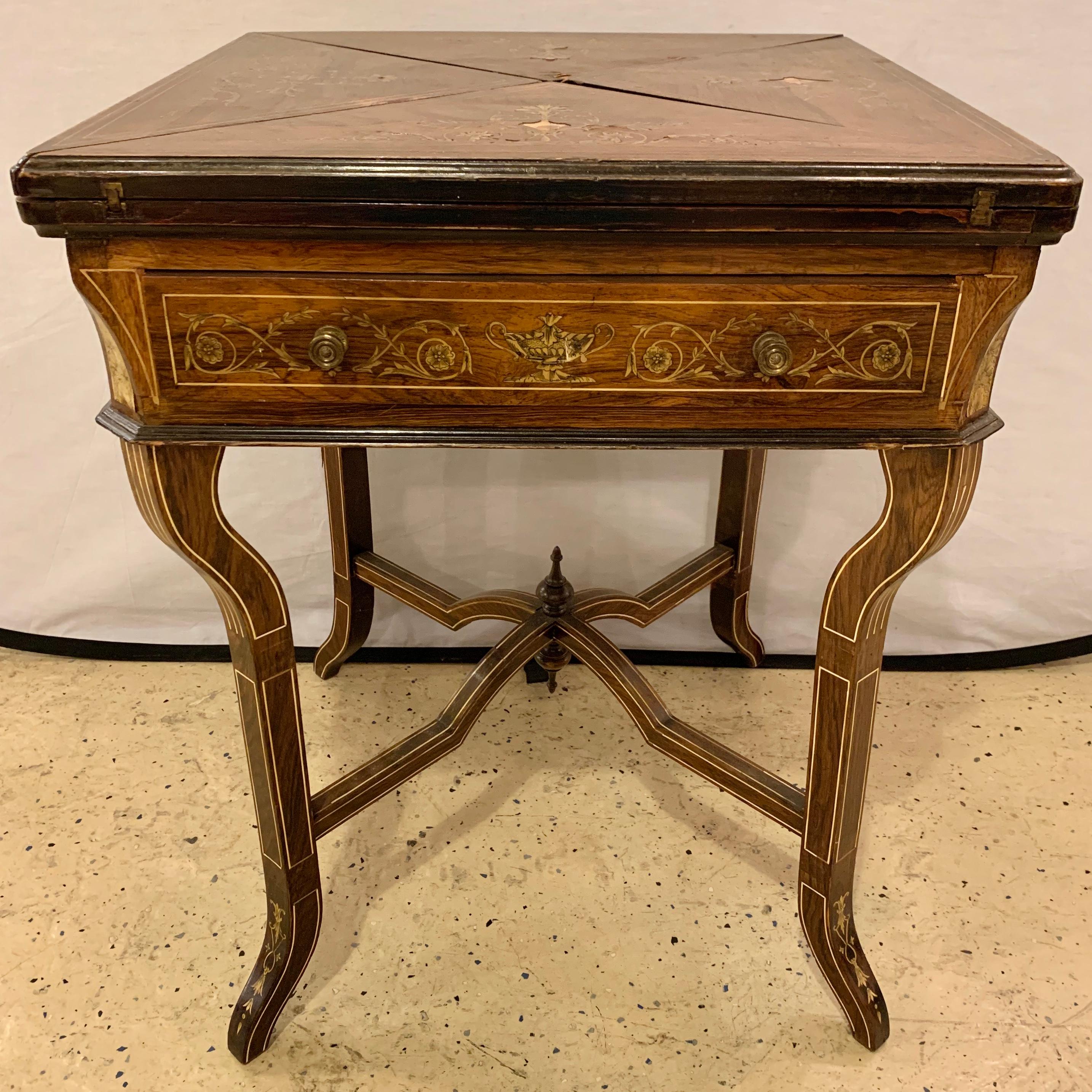 19th century rosewood English card table. A unique card table having a finely inlaid tabletop of rosewood having an open handkerchief form leading to a felt center with cup or chip indentations. The case with a single drawer and all-over inlays of