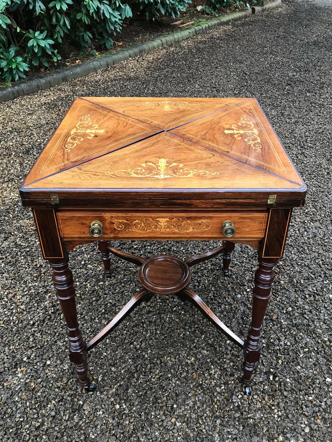 19th century rosewood marquetry inlaid envelope card table with fitted drawer. Extremely well made, decorated throughout. On turned supports united by an X framed stretcher with a circular under tier.

circa 1890-1900.

     

   