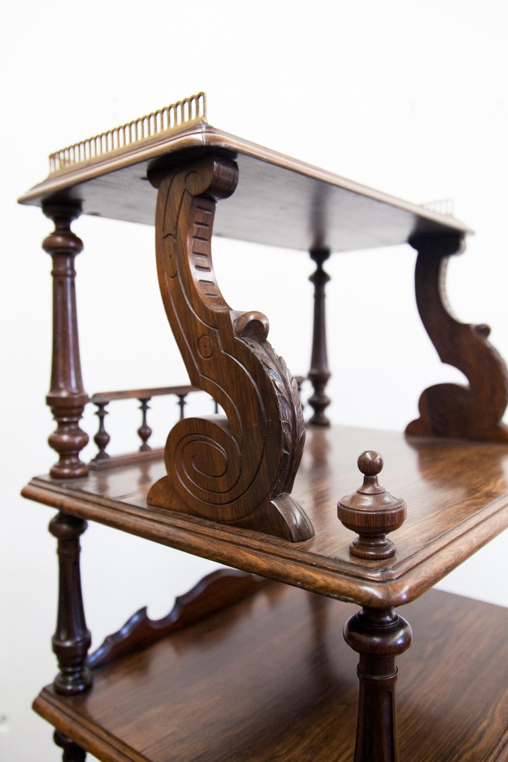 19th century rosewood four-tier shelf, with fluted supports and brass and wood galleries, vertical storage compartments below, on castors.