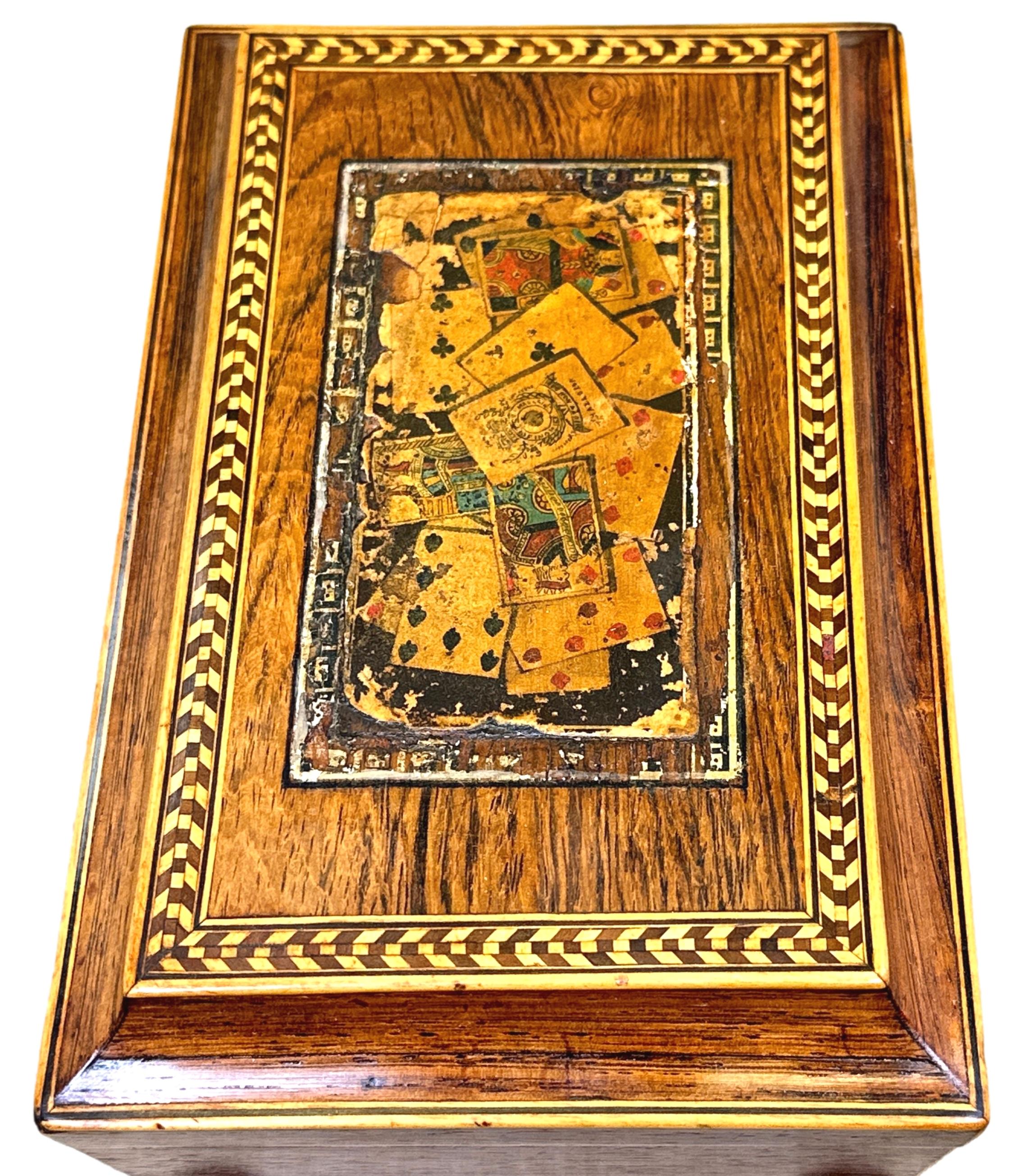 A very attractive Mid-19th Century rosewood card, or games, box having charming polychrome cards and chequered strung decoration to hinged top, enclosing paper lined interior with divisions for playing cards and counters, raised on original turned