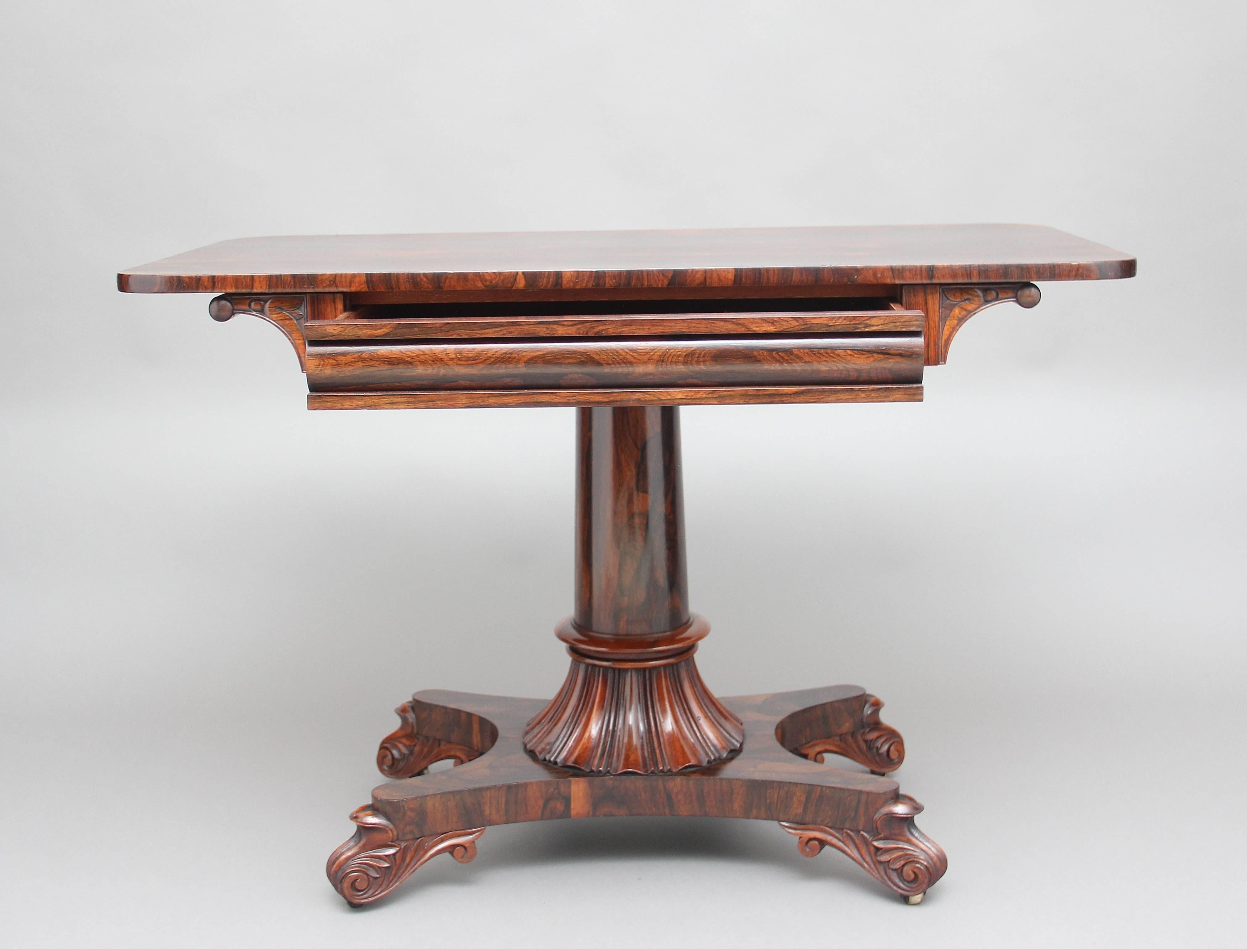 19th century rosewood library/sofa table, having a lovely figured top above a single mahogany lined drawer, supported on a turned and fluted column ending on a shaped platform base with elegant carved and shaped feet, circa 1840.
     