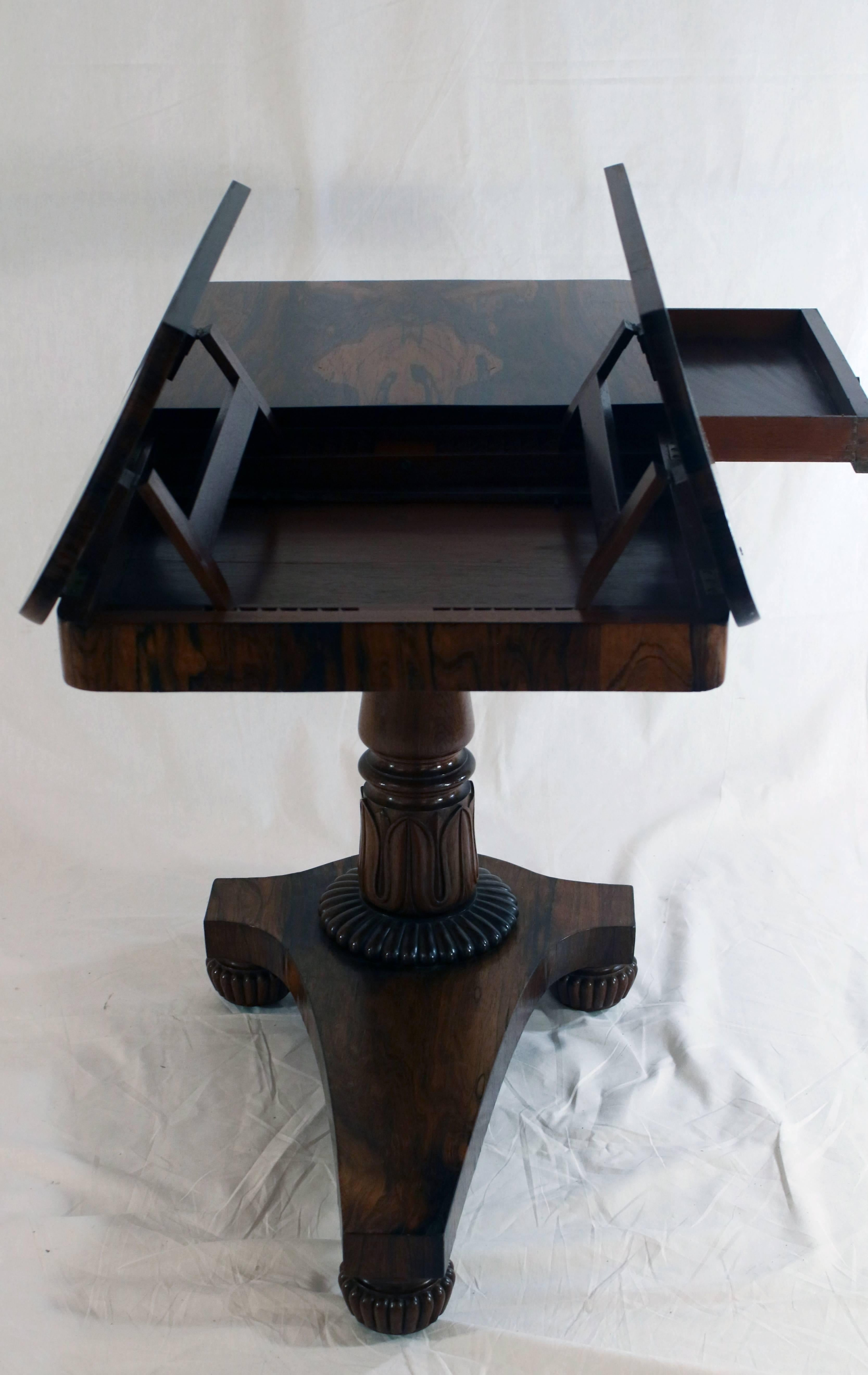 English carved rosewood duo angle adjustable bookrest reading table in the Regency style on ratchet-cantilevered base with single drawer, circa 1840. This table was created to provide a stabile surface upon which to enjoy reading large books which