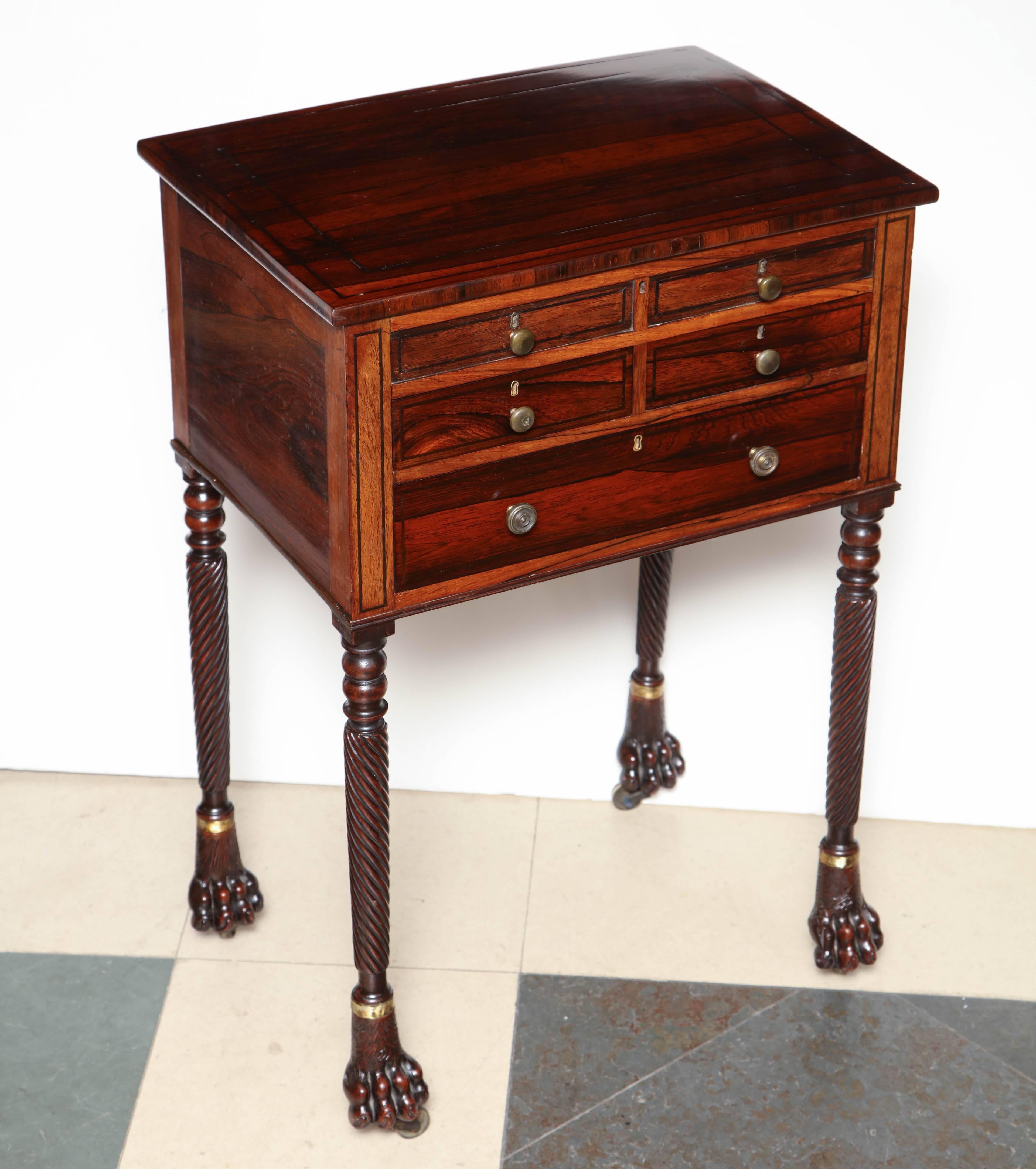 A Regency 19th century rosewood lift top side table with ratchet adjusting interior writing surface on turned and reeded legs and dog paw feet. Attributed to George Oakley.