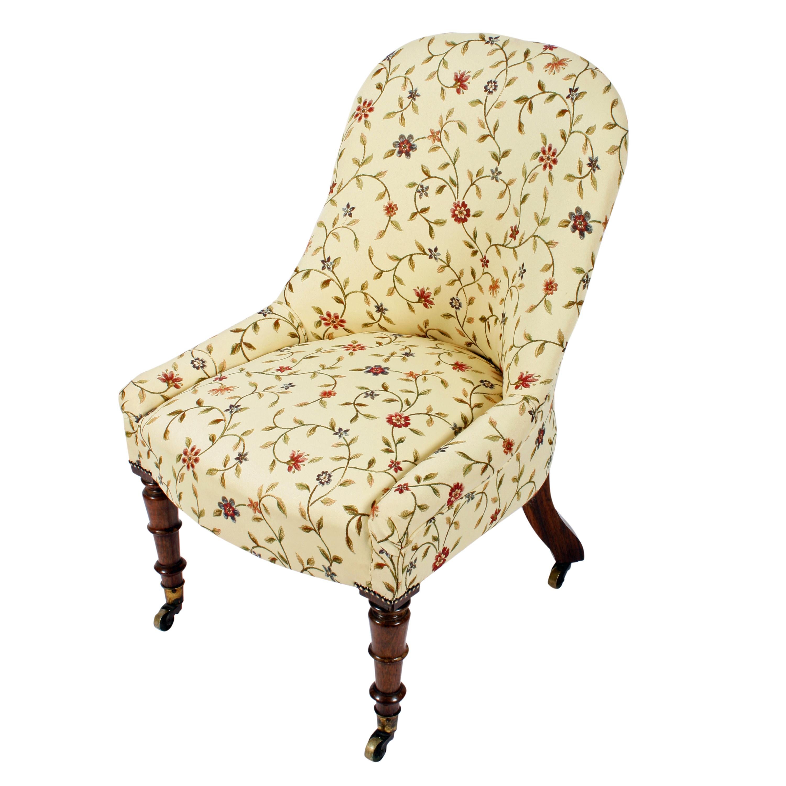 A middle of the 19th century Victorian slipper chair.

The chair has a fully upholstered rounded back and low rolled edge arm rests.

The front legs are turned rosewood with gilt brass casters and the back legs kick out and also have