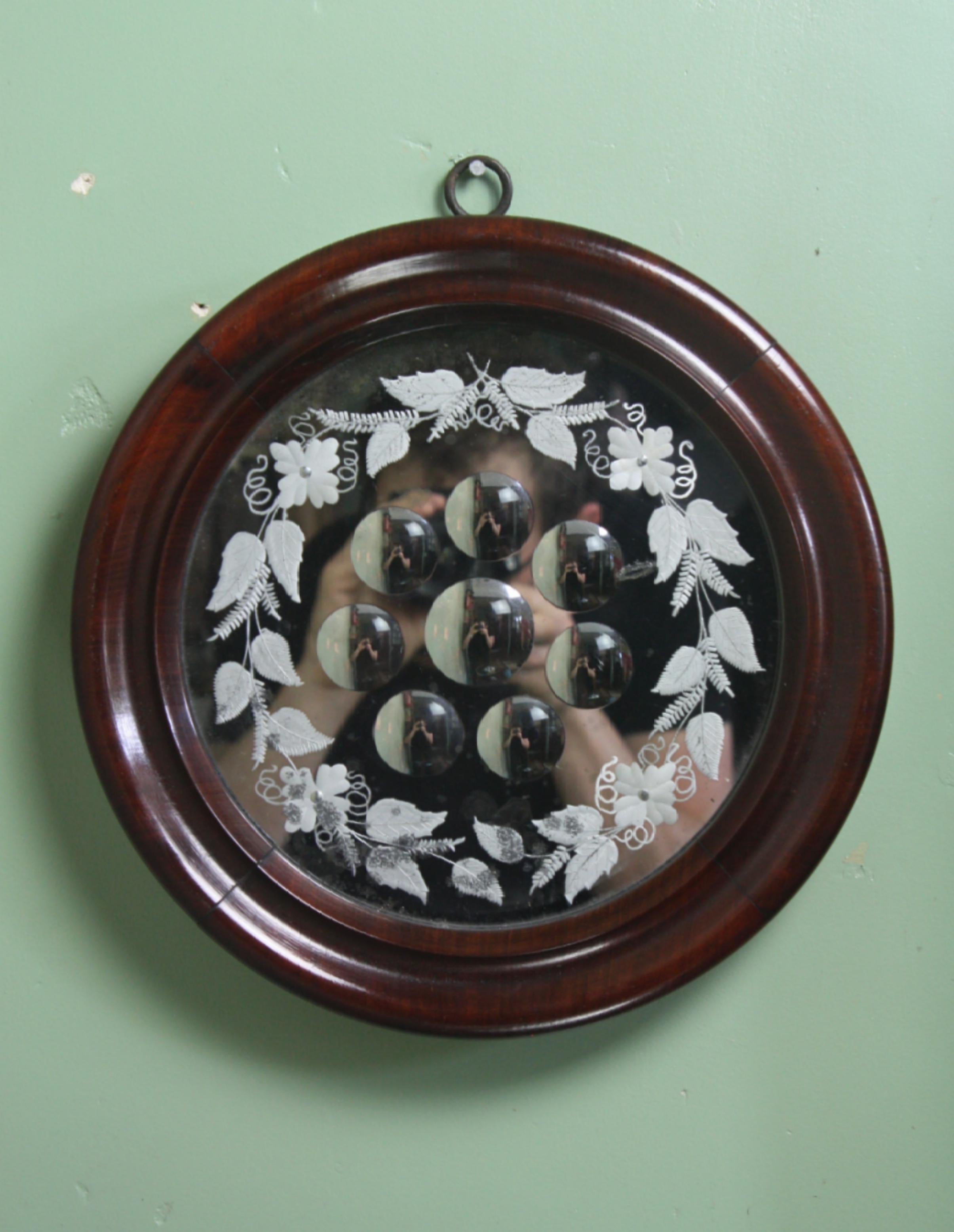 A decorative and large sorcerers mirror, with eight reverse ground optics with an acid etched floral border. The mirror plate has age related oxidizing and pitting, the frame is rosewood as is of a lovely color

In all round excellent condition