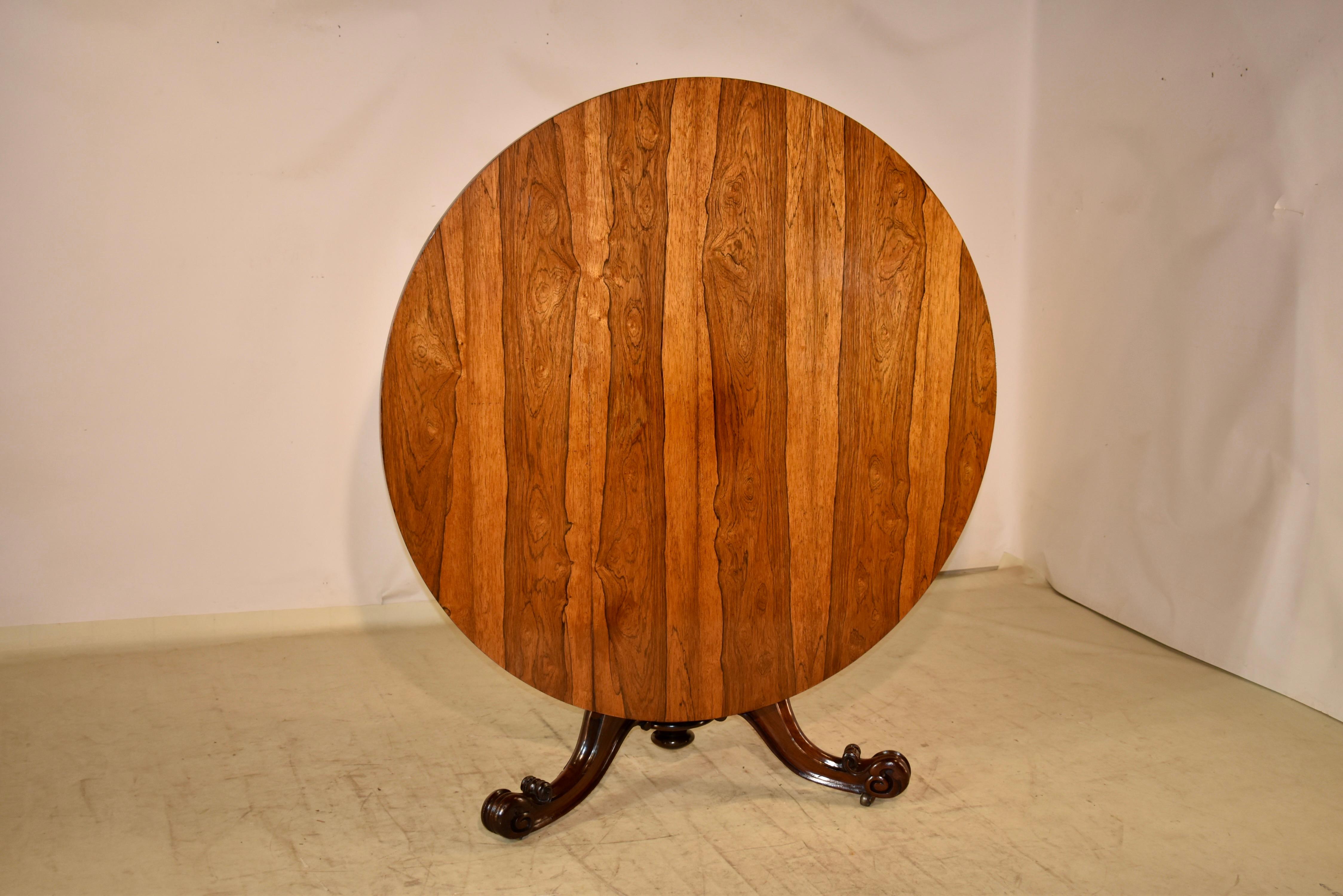 19th century rosewood tilt top table from England.  The top is made from the most beautifully grained rosewood we have ever seen.  The color is so vibrant, it almost looks alive!  The top has a simple apron and is supported on a graduated tapered