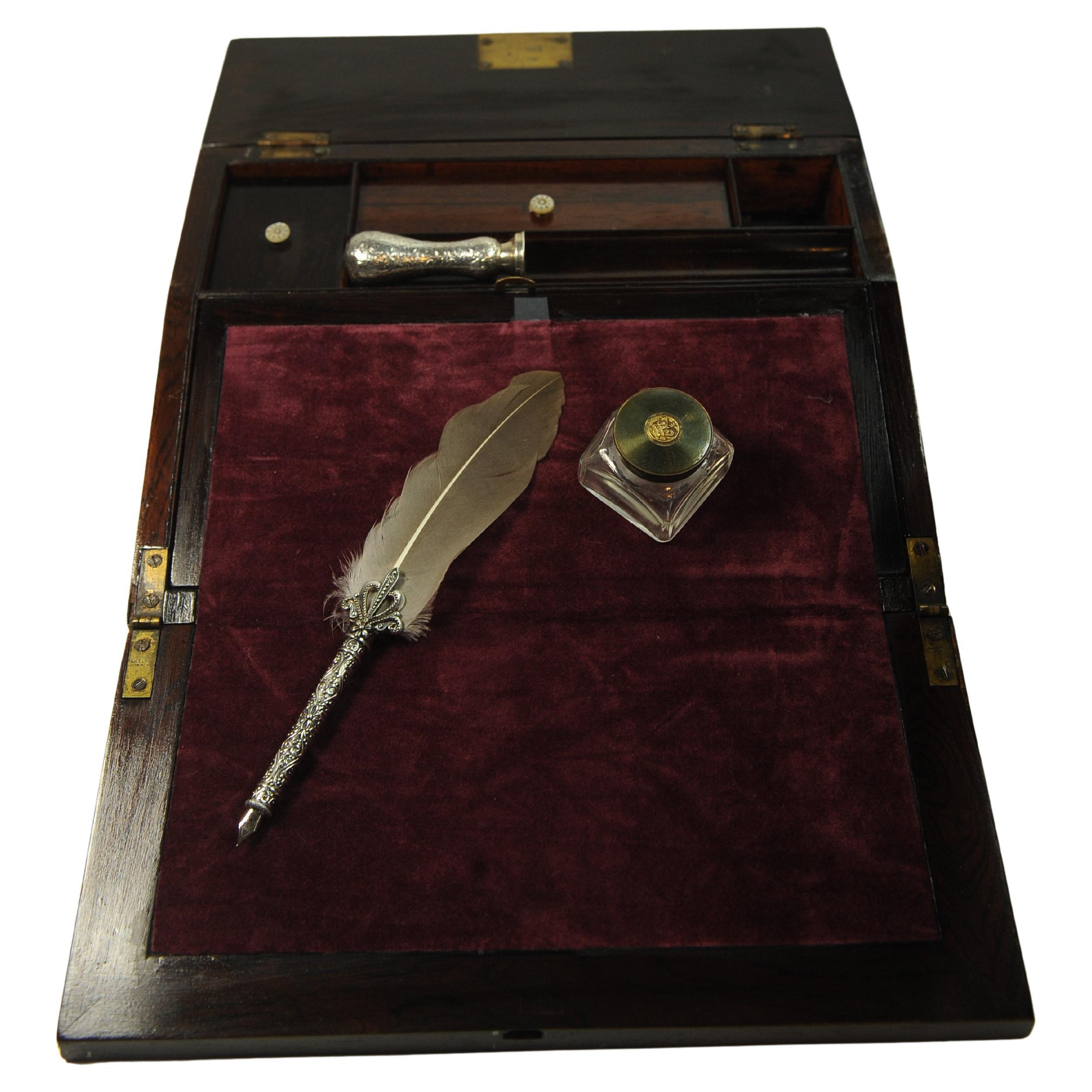 Piano di scrittura in palissandro del XIX secolo decorato con eleganti intarsi.

Il pendio è caratterizzato da un interno ben rifinito, purtroppo privo di scomparti nascosti.

L'interno, una volta ripiegato, è rifinito con un pendio di velluto verde