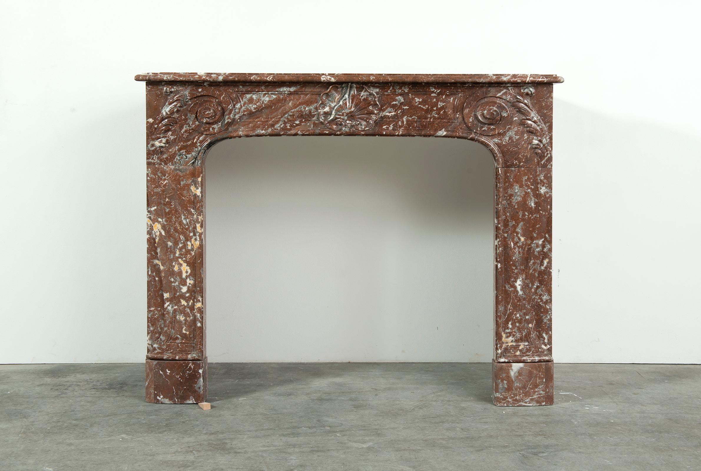 19th century Rouge de Mazy marble Louis XV fireplace mantel. Opening measurements: 34.6 x 39.8 inch (height x width).
