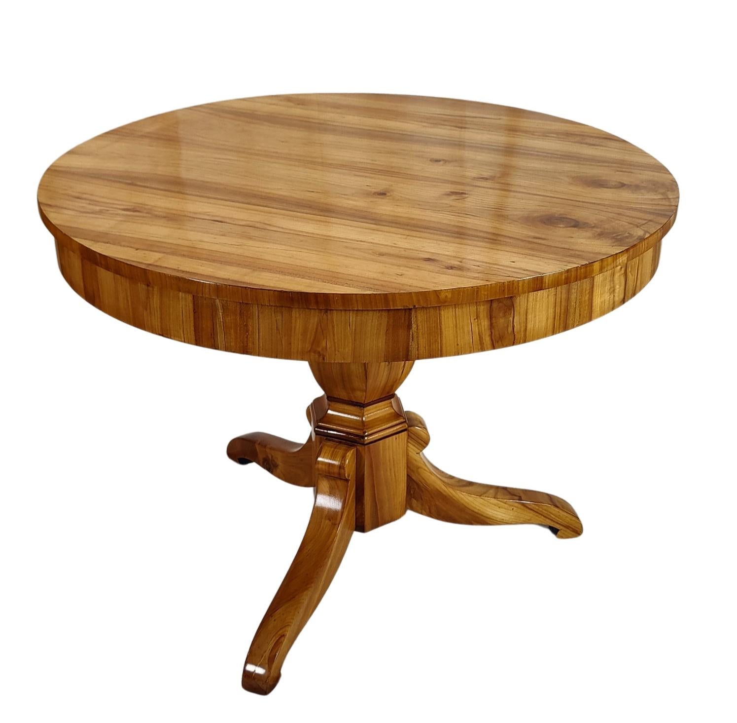 La table est recouverte de placage de cerisier. La table date du début du 19ème siècle, de la période Biedermeier. Comme la table a un cadre bas, il y a beaucoup d'espace pour les jambes lorsque l'on s'assoit dessous. La hauteur du sol au cadre est