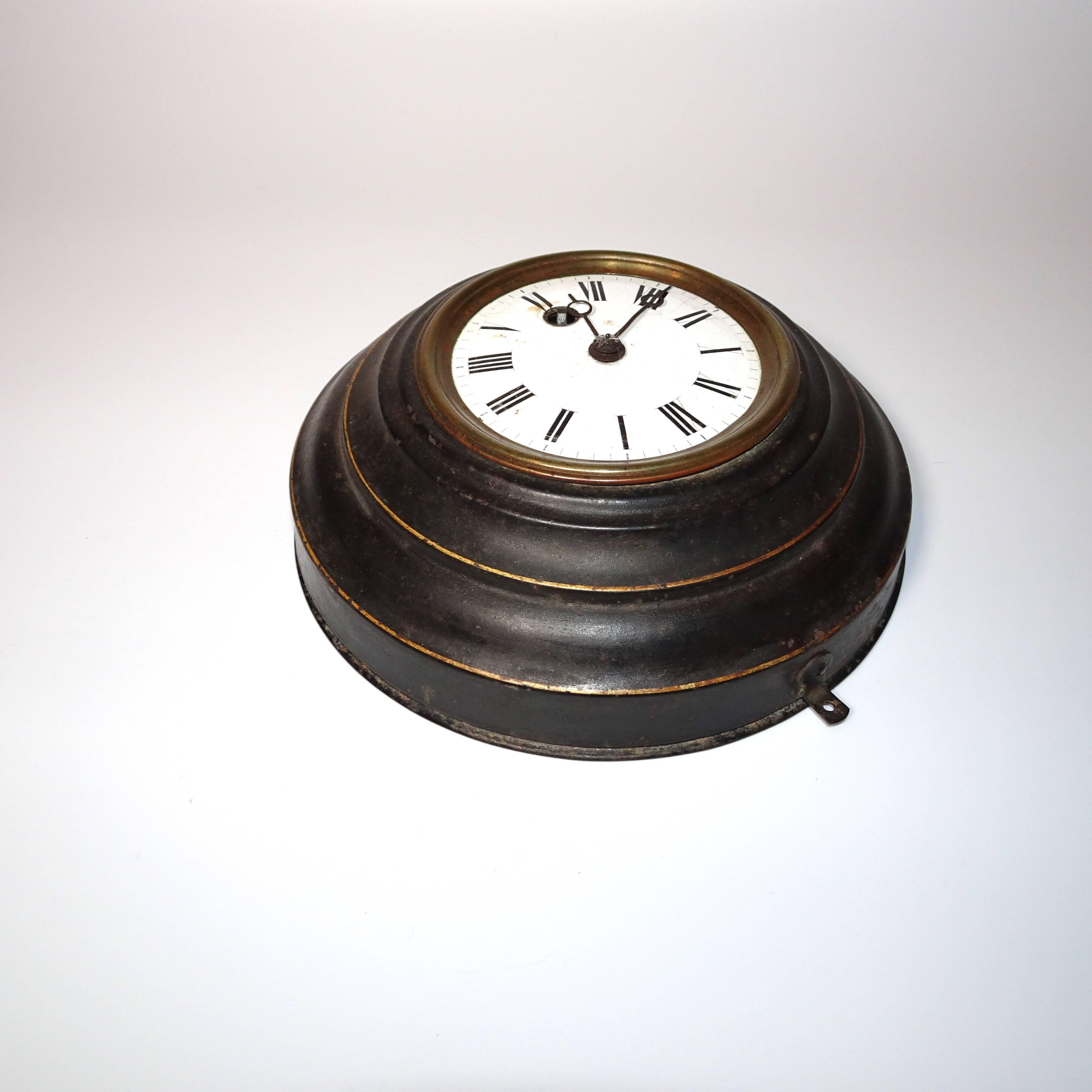 Decorative round black tole clock, 19th century English. The clock has a white face. 
  