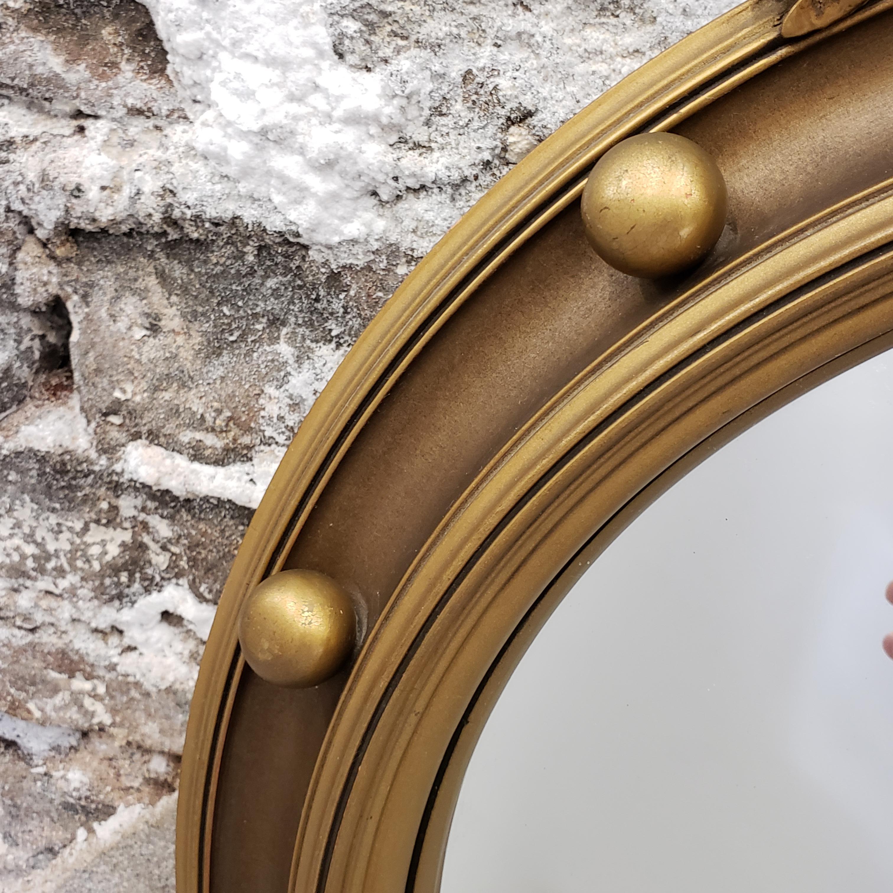 Nineteenth century giltwood convex wall mirror with ball and ribbon decoration.