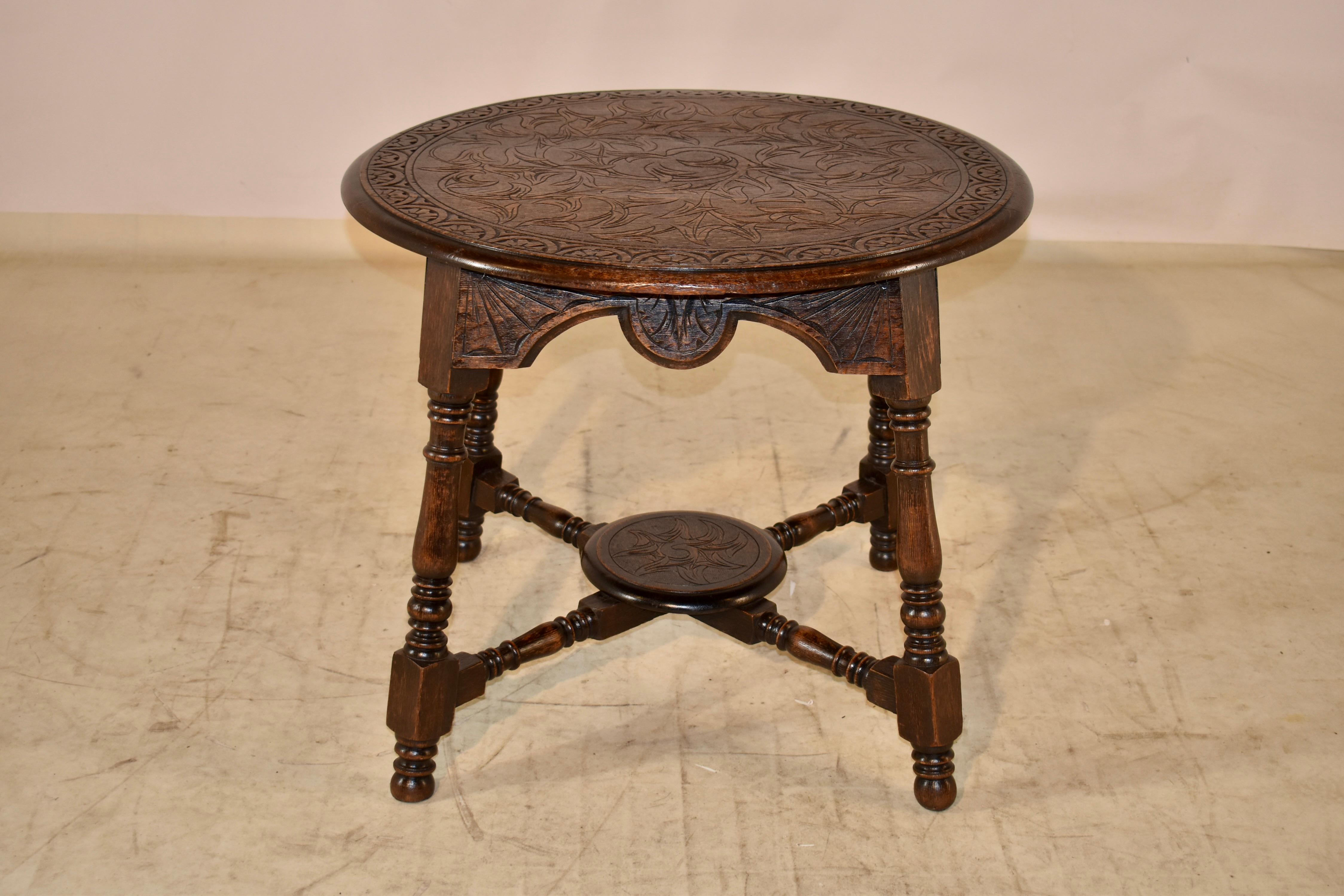 19th century oak round side table from England with a beveled and hand carved decorated banded edge around the top, surrounding hand carved leaf and vine decoration in the center of the top. This follows down to a shaped and carved decorated apron