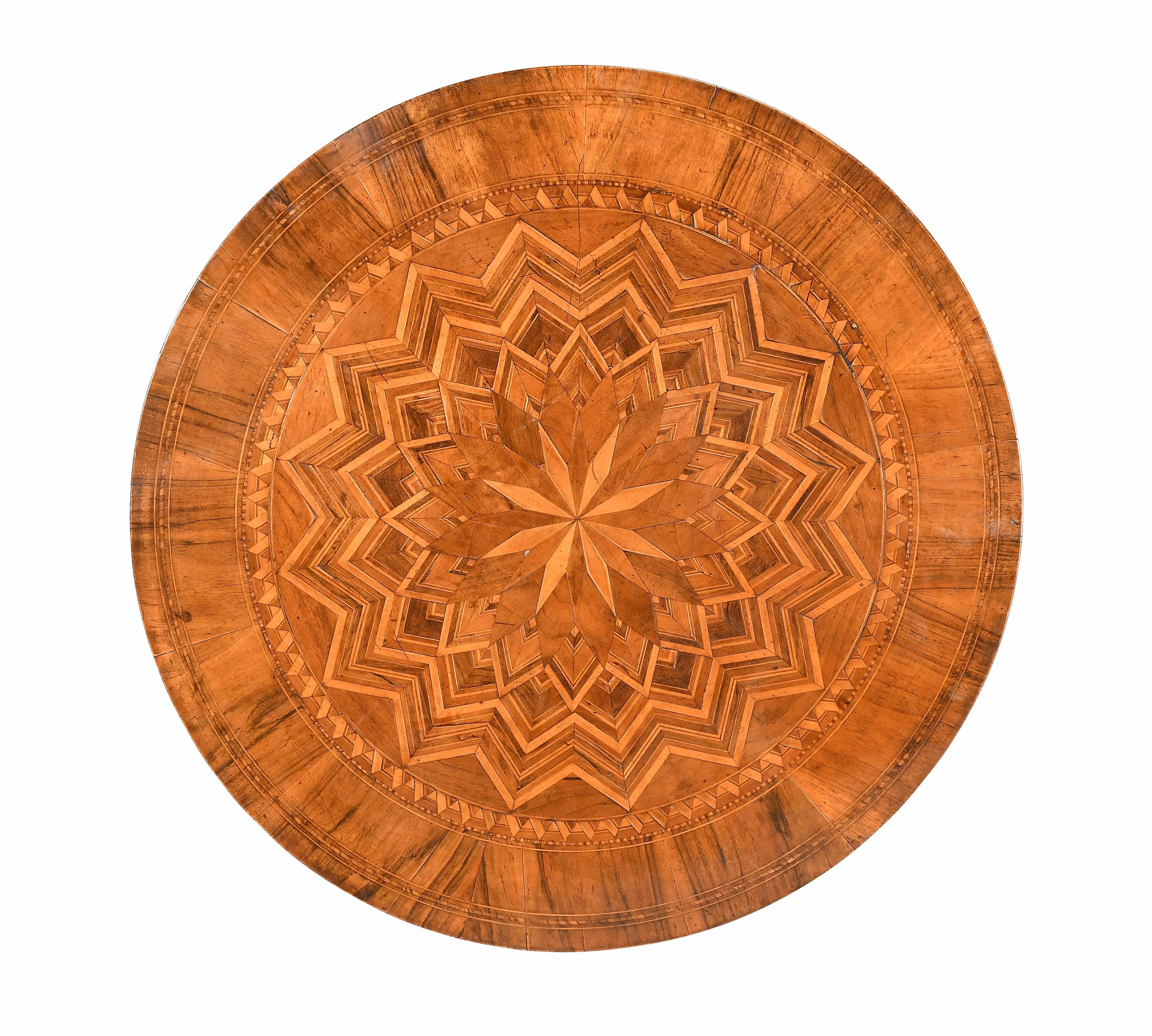 A round parquetry table with inlaid starburst pattern to the top in a variety of contrasting woods. The turned column support is also inlaid. The shaped legs inlaid with a feather-banded pattern. Typical of the remarkable parquetry work of Sorrento.