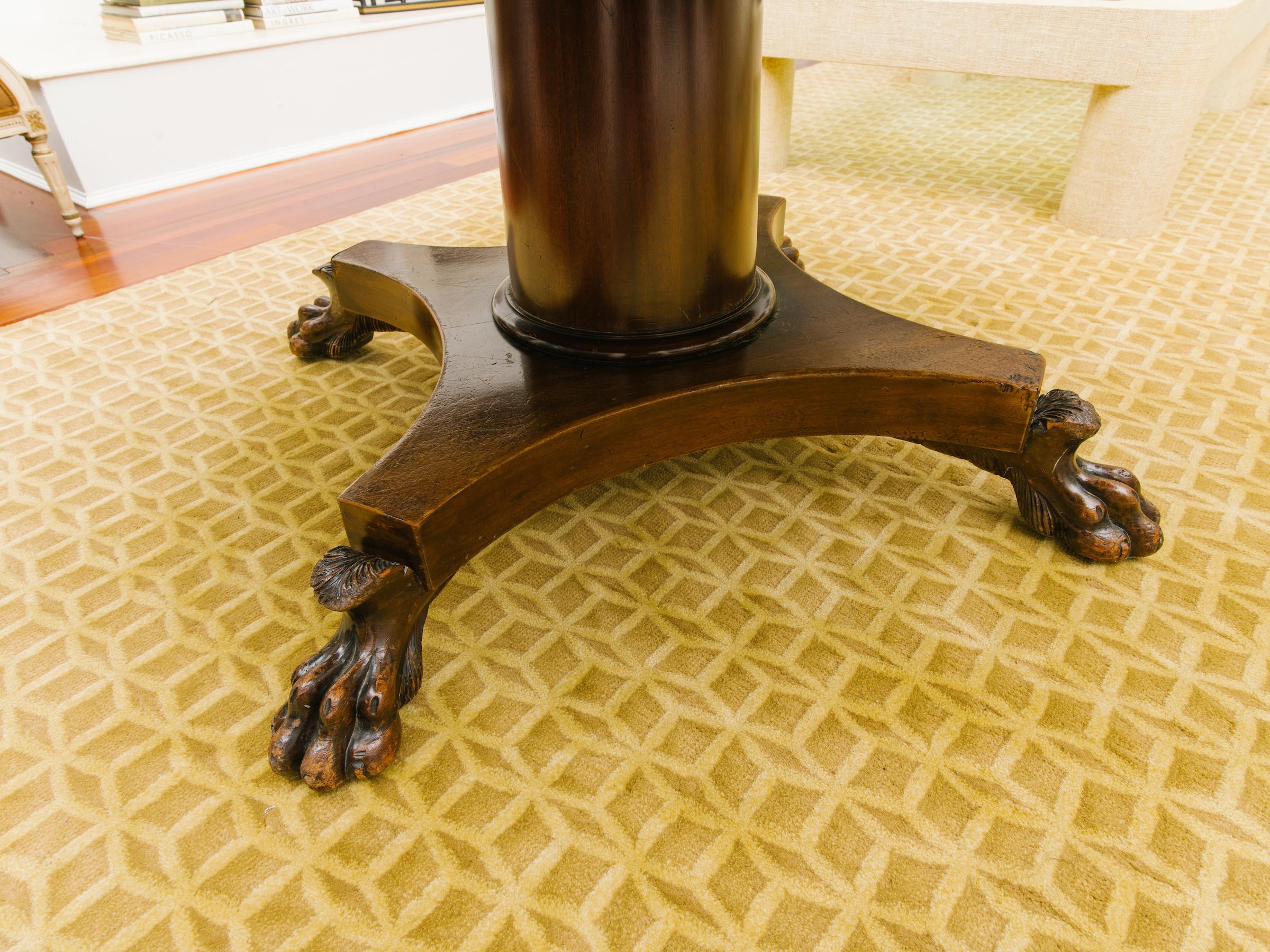 19th century round Regency mahogany dining table with lion paw feet.