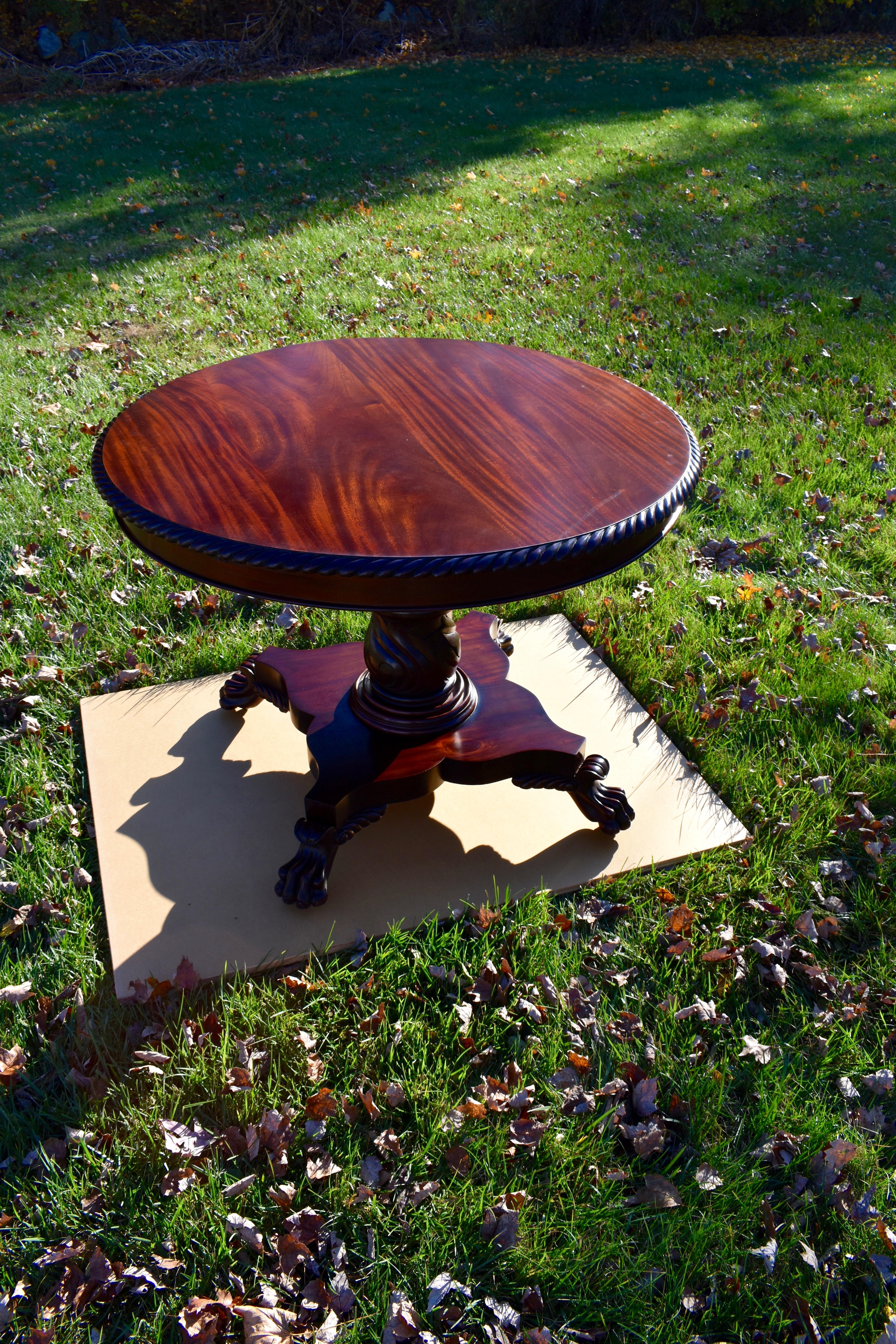 19th century round Regency mahogany table with lion paw feet, rope twist border. (1890) this is a fine example with the top recently refinished and base was brightened as well. Top can be removed by a series of screws. Feet also have metal caster