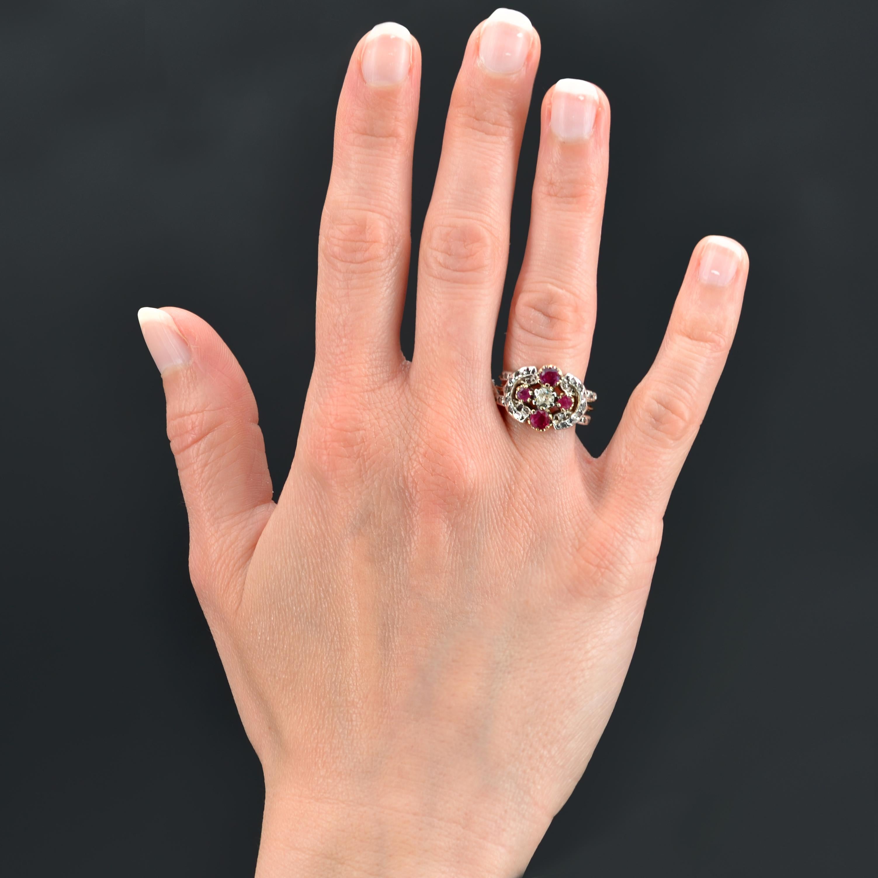 Ring in 18 karat yellow gold, and silver.
Antique ring of charm, it is decorated on its top of a brilliant- cut diamond and 4 round rubies, the whole forming a cross. An openwork silver decoration set with rose-cut diamonds frames this design. Three